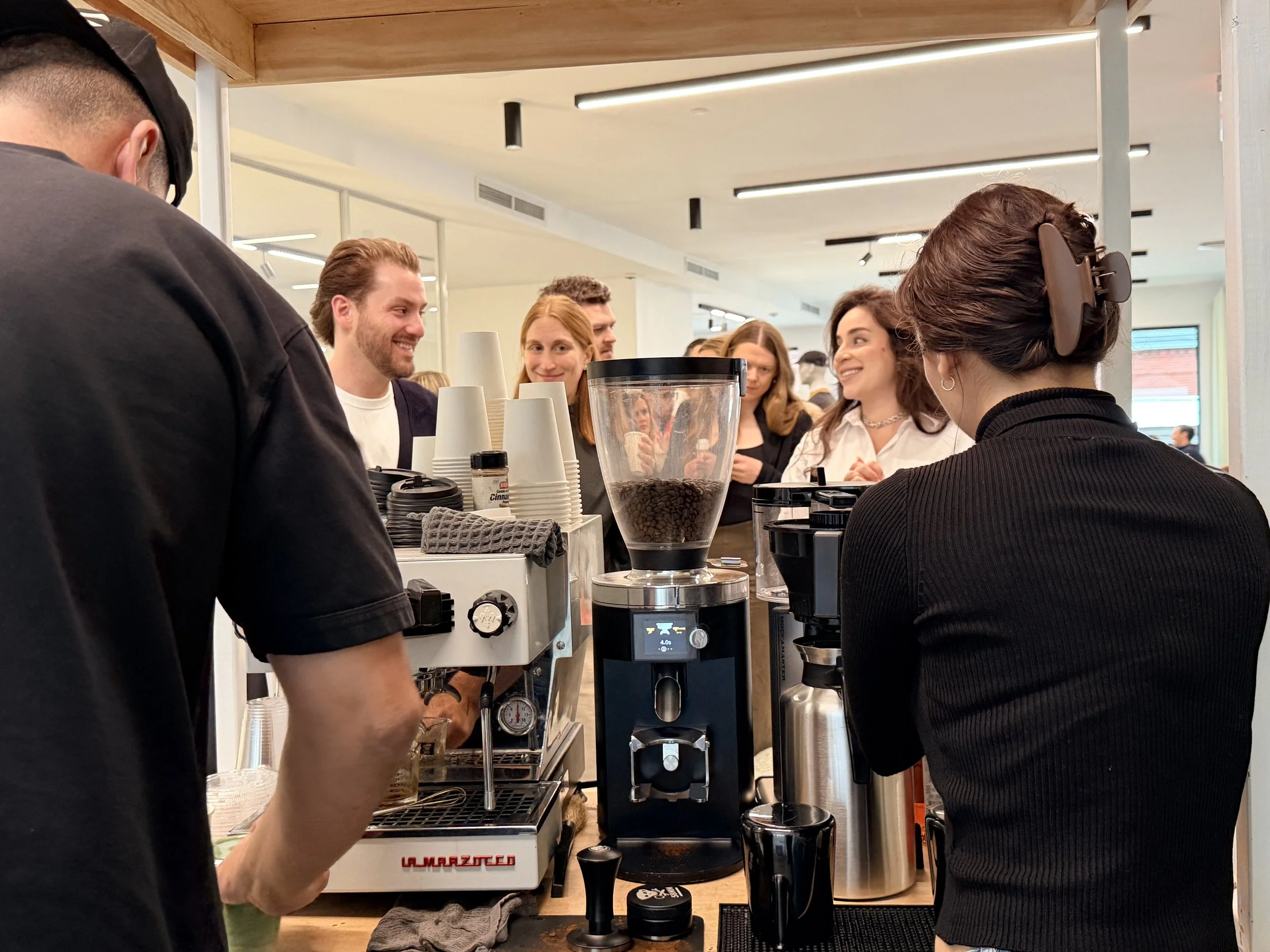 guests lined up to grab a delicious cup of coffee made by the coffee cart set up by a place coffee brewers