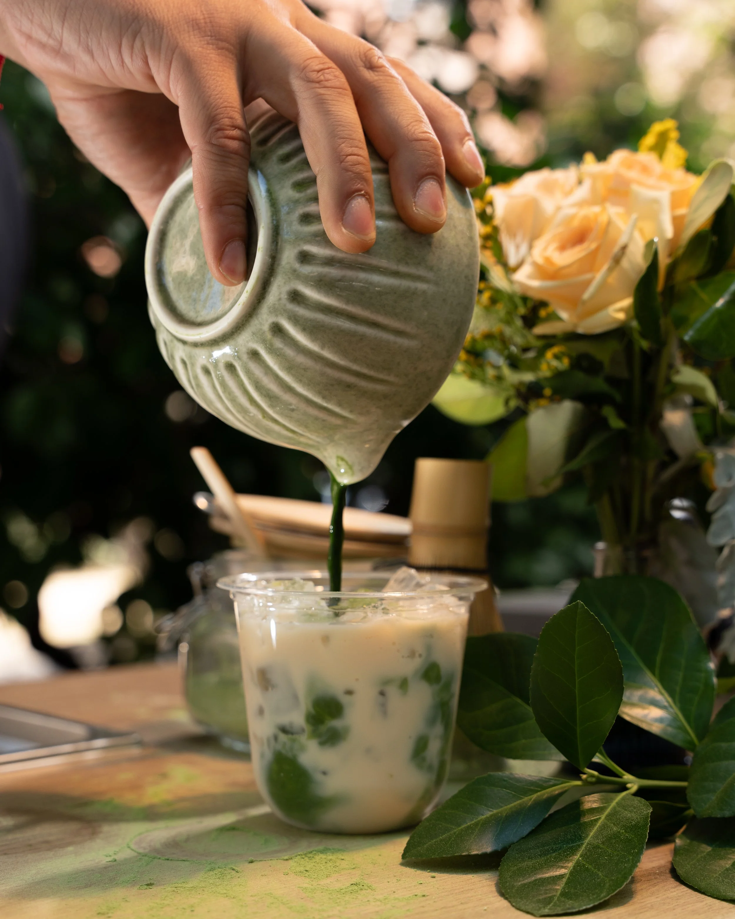 barista serving an iced matcha latte