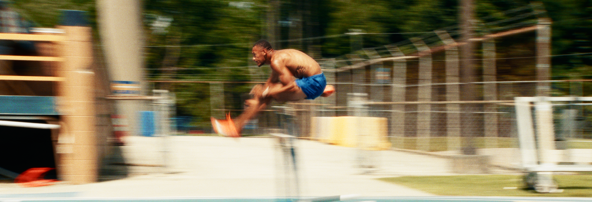 A man jumping into a swimming pool with motion blur.