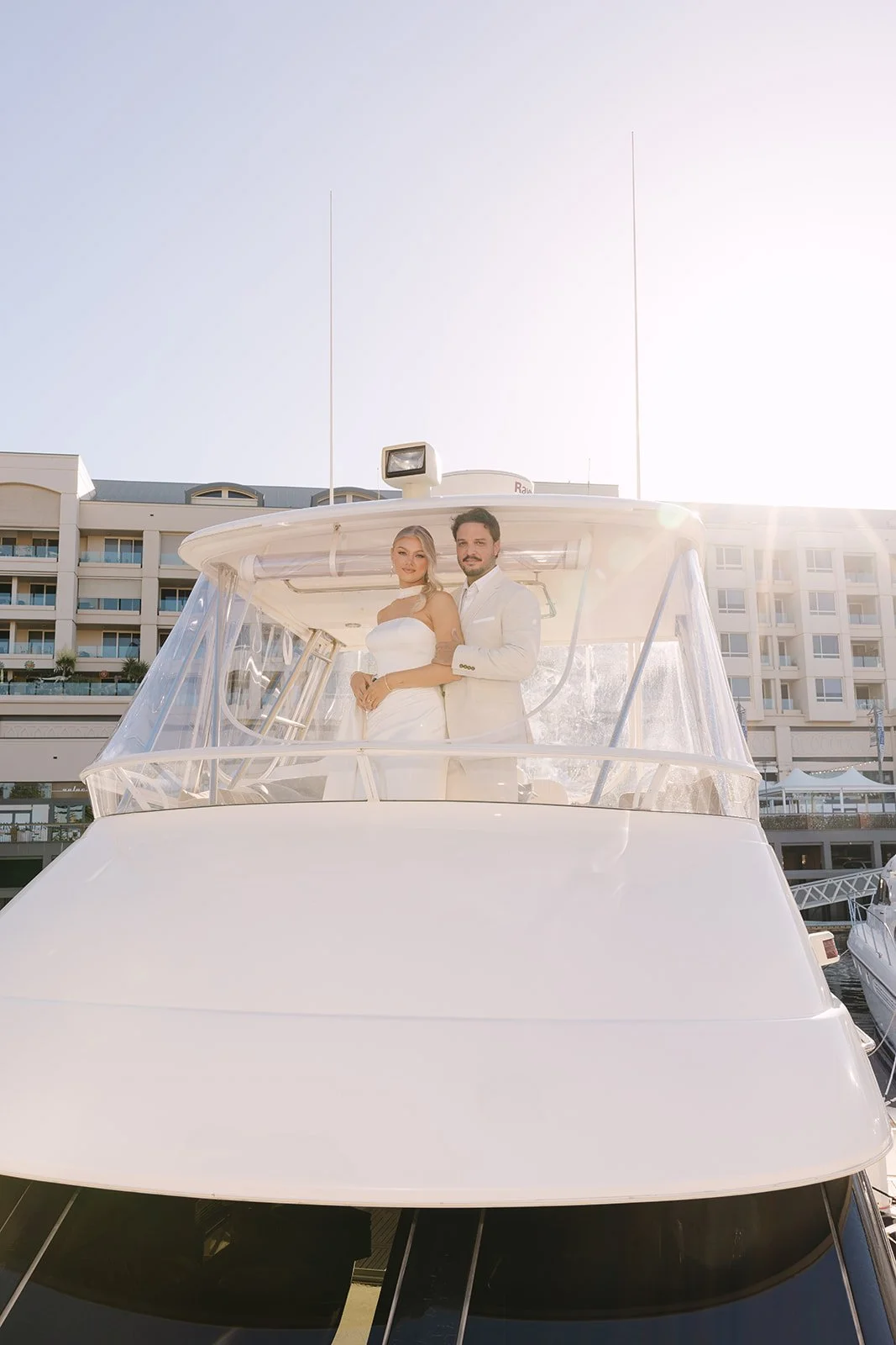 Modern bride wearing designer wedding dress with silk scarf styling on yacht editorial shoot