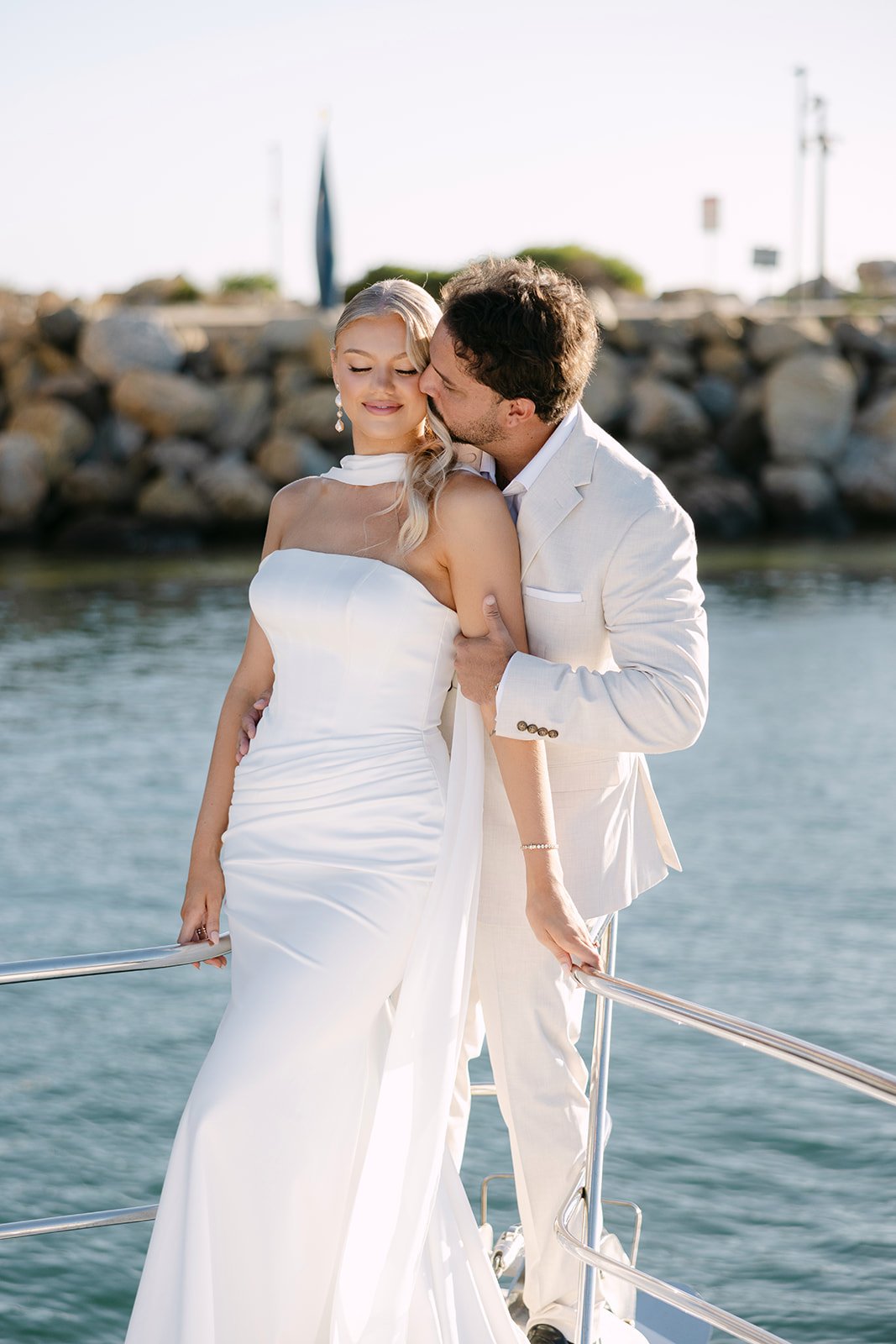 Bride wearing Jane Hill wedding gown with chiffon scarf flowing in the wind on yacht editorial shoot