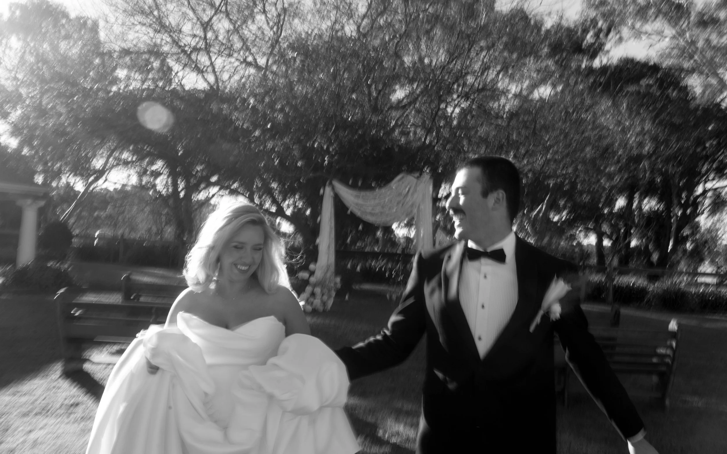 bride running happy with groom ater ceremony in a trish peng gown at Brin Farm black and white image
