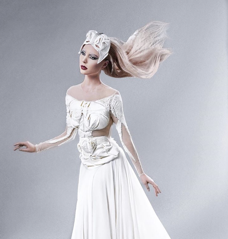 The photo presents a high-fashion alien look featuring a half-human, half-universe theme, with makeup and hair styling by Suhaila. The avant-garde design blends cosmic elements with striking elegance, creating a visually stunning and otherworldly app