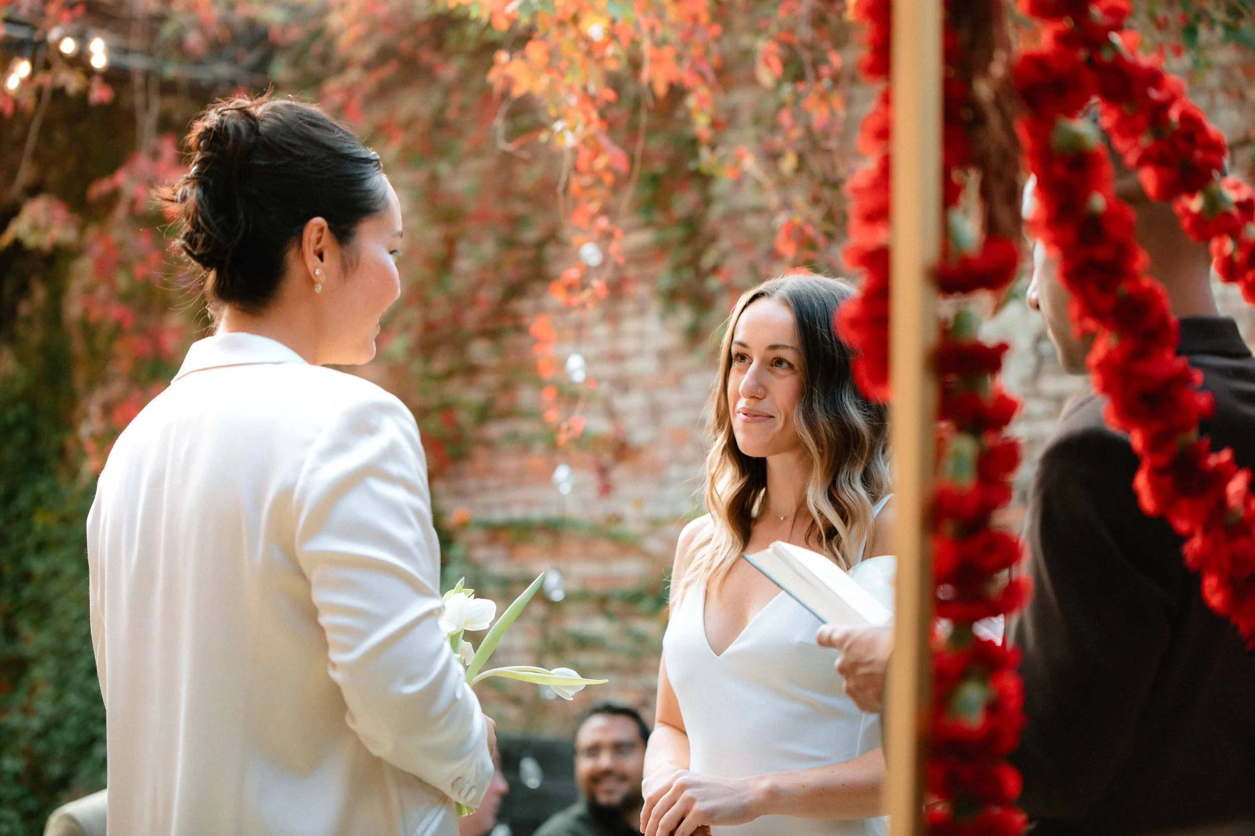 wedding couple smiling and looking at each other at altar during ceremony at cannonball factory luxury wedding venue in Hudson NY