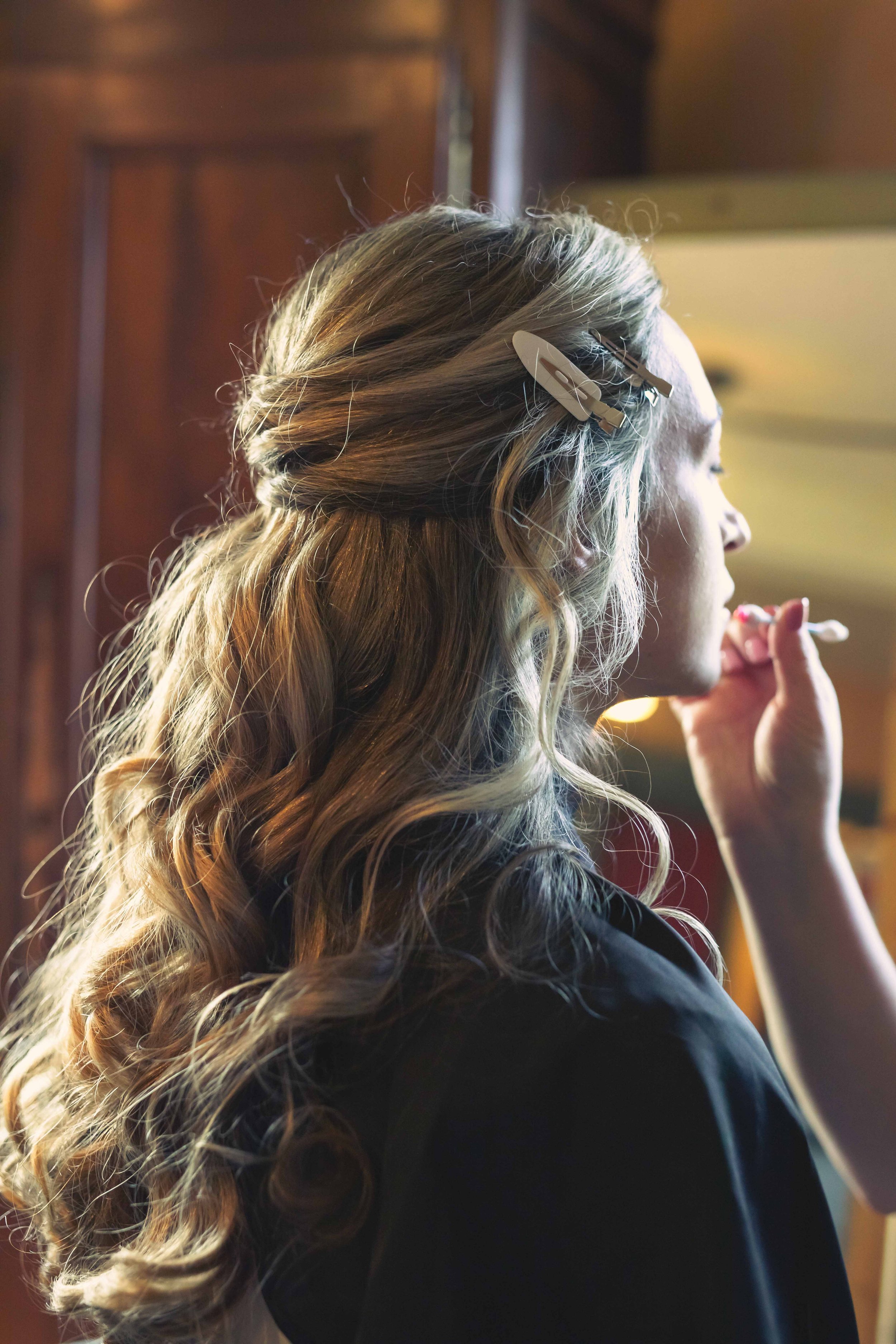 bride getting ready with make-up artist in window light in historic home in upstate NY fall wedding at FEAST at Round Hill wedding venue in Washingtonville NY
