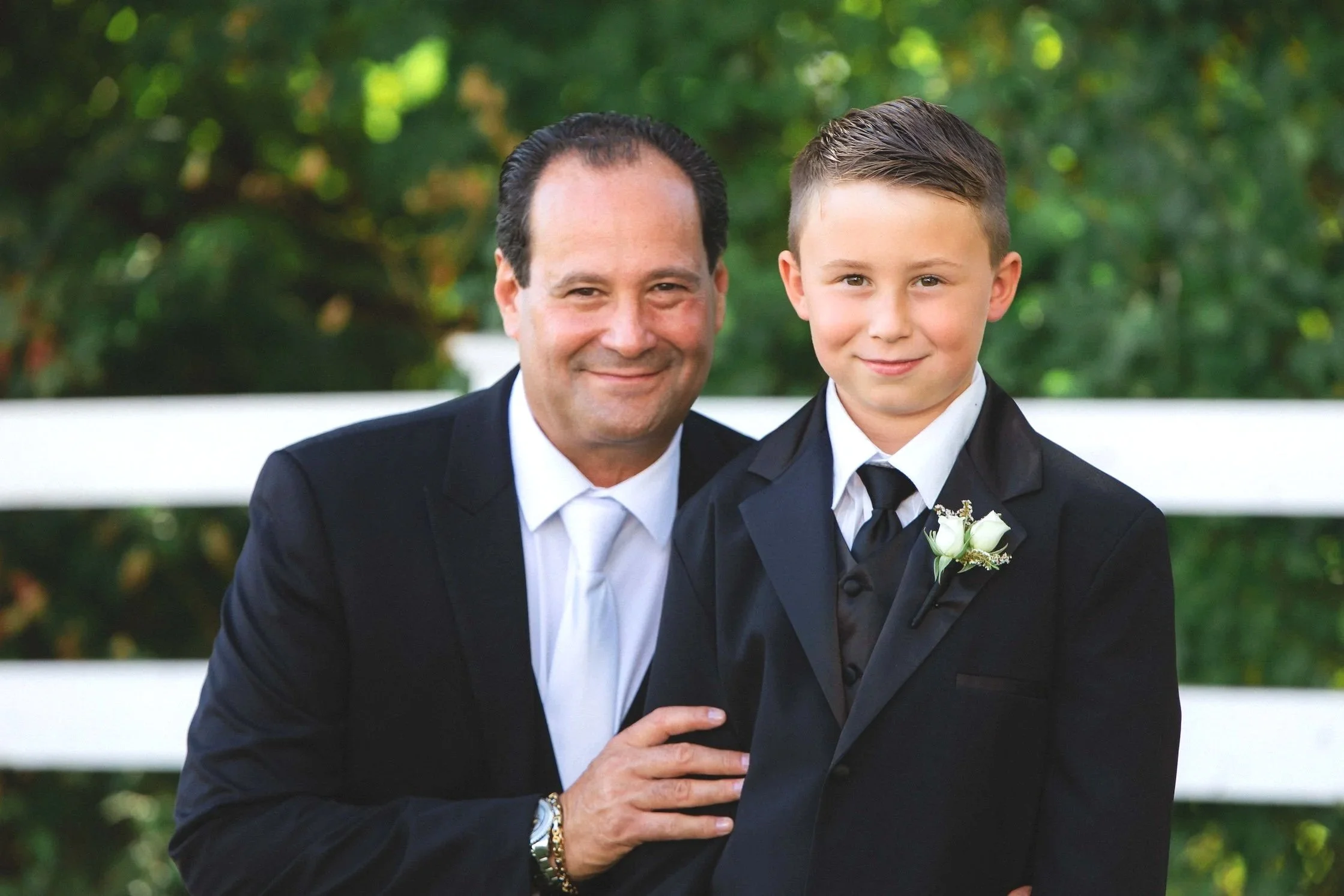 Groom smiling poses with his son for formal photos before wedding ceremony at The Sagamore Resort in Bolton Landing on Lake George, NY