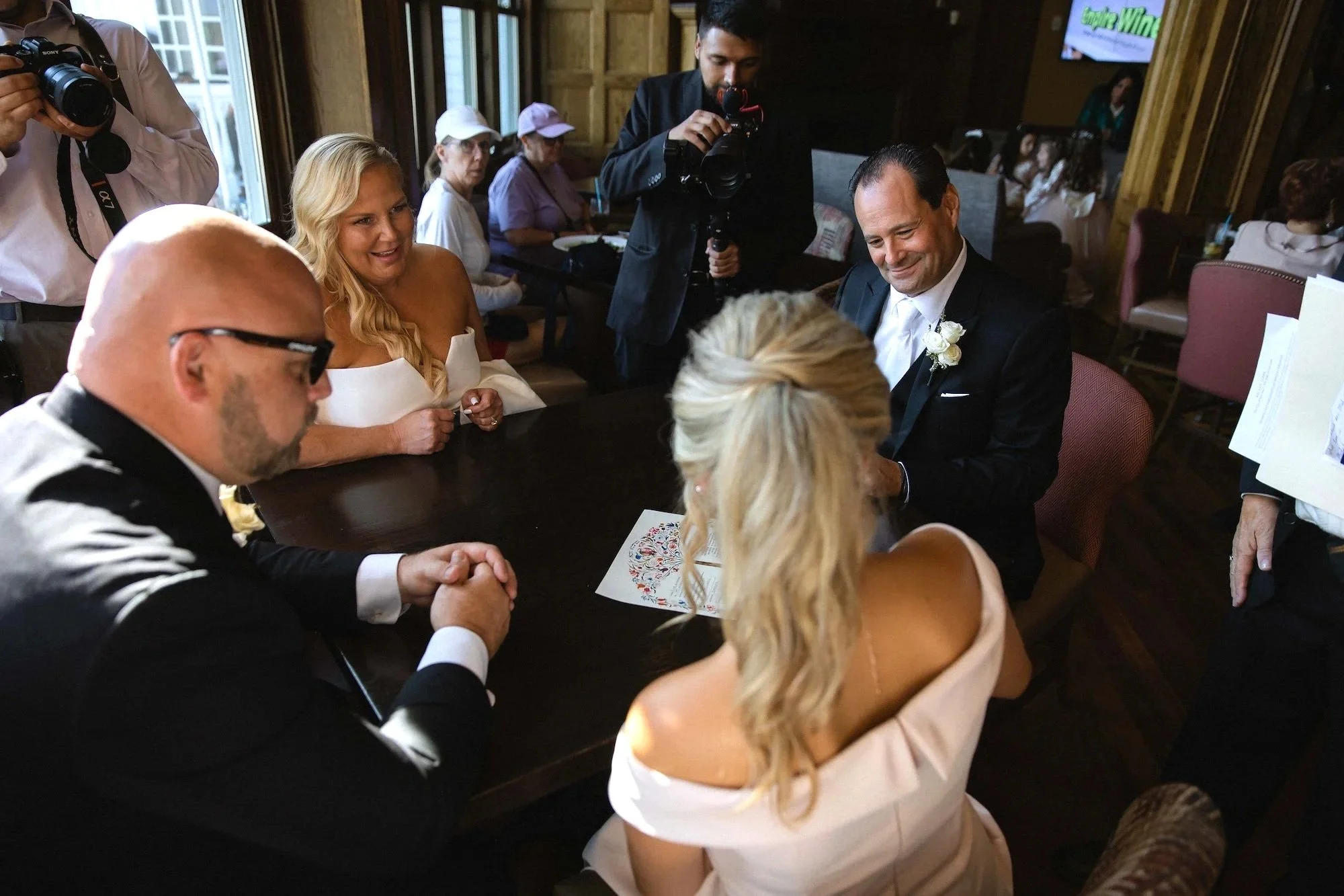 bride's daughter signing ketubah wedding contract in the restaurant before wedding at the sagamore resort in bolton landing on lake george ny