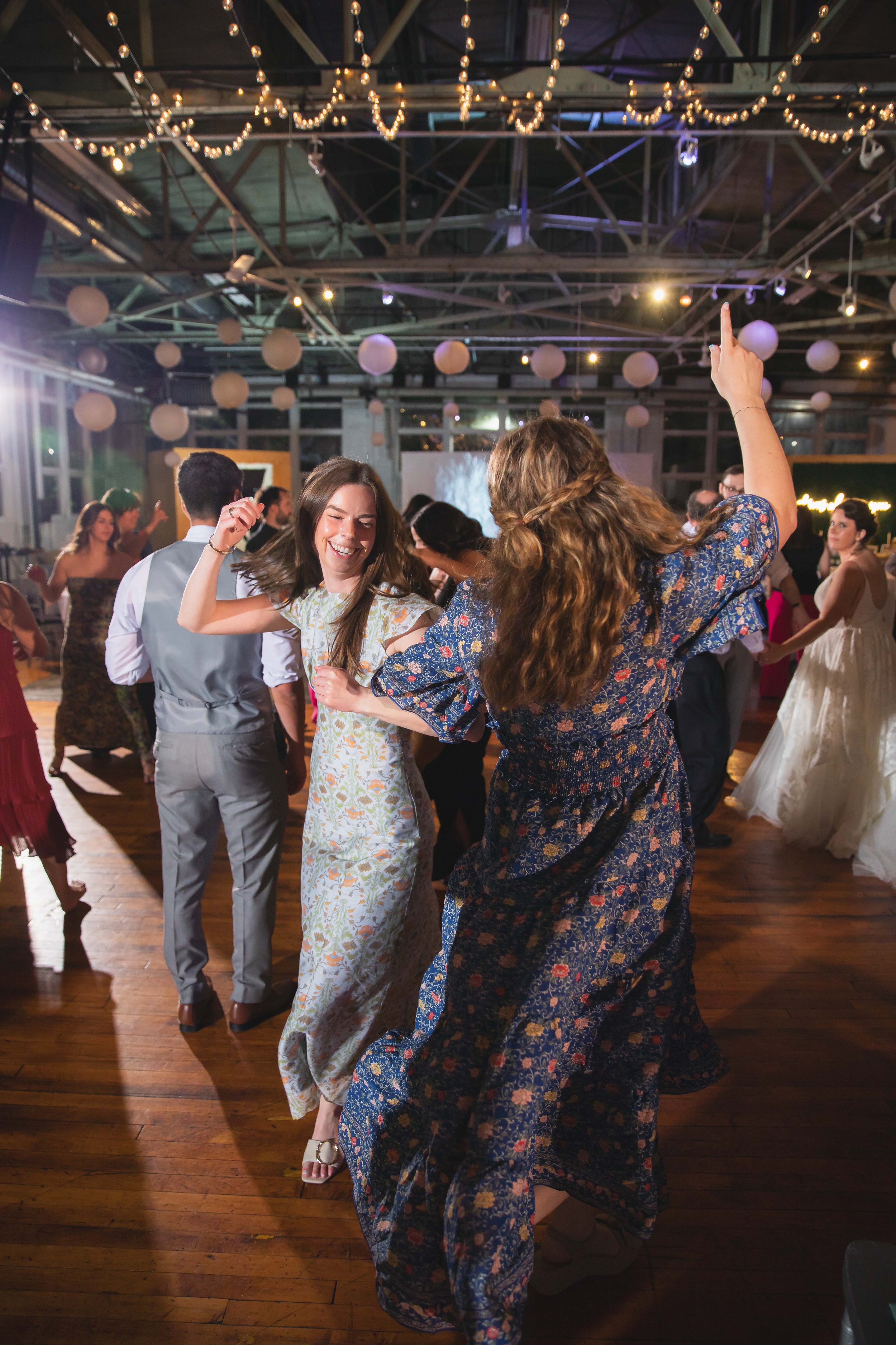 wedding guests smiling and laughing during hora dance at reception dinner at Saugerties Performing Arts Factory chic industrial wedding venue in upstate NY