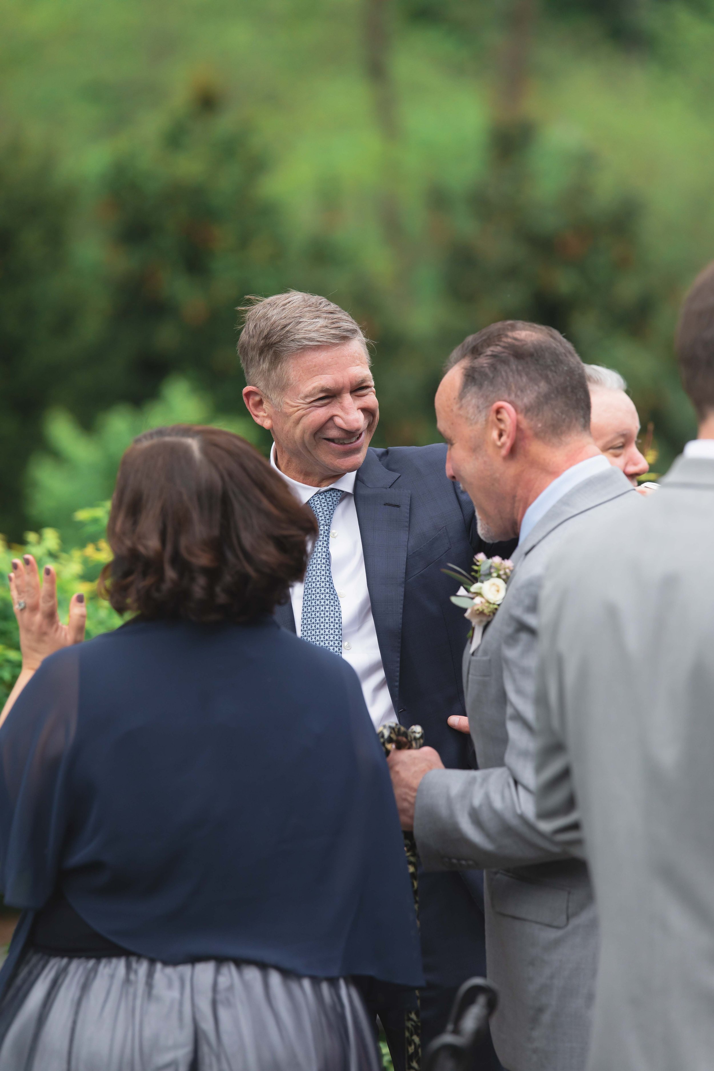 wedding guests smile talk and greet each other on patio after ceremony at Saugerties Performing Arts Factory chic industrial wedding venue in upstate NY