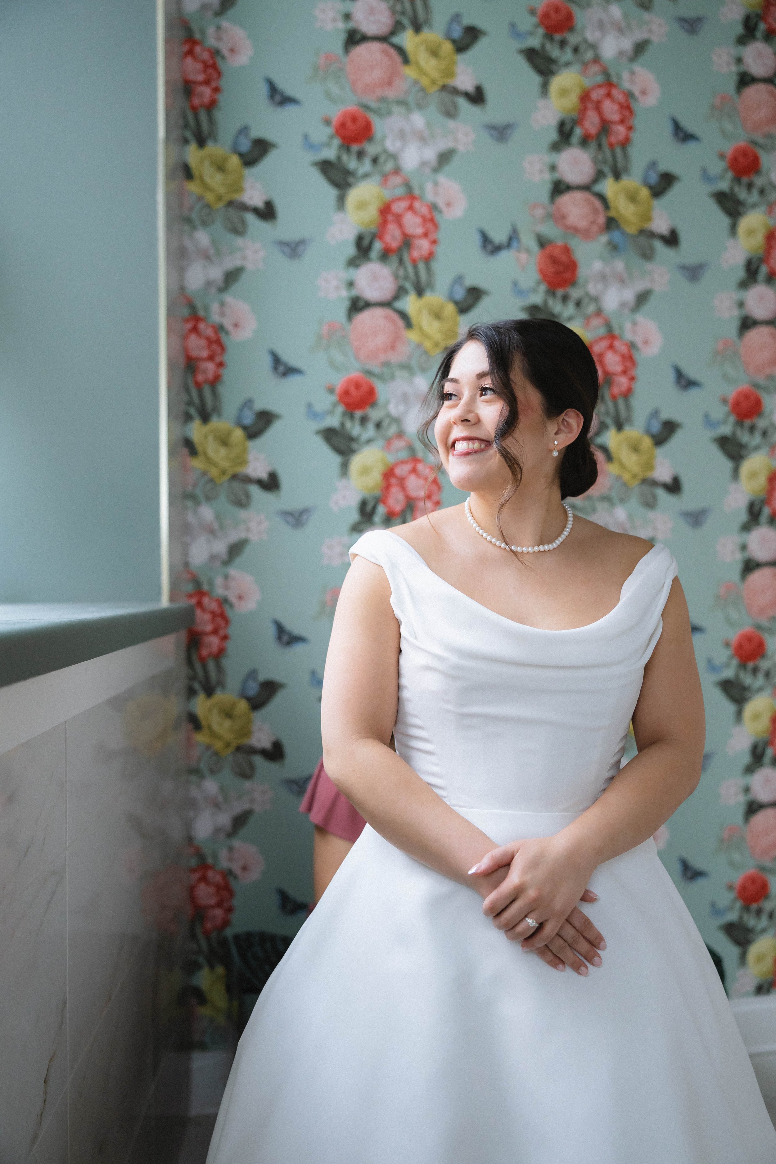 luxury wedding photograph of smiling bride looking out window of bridal suite at Kenmore Ballroom