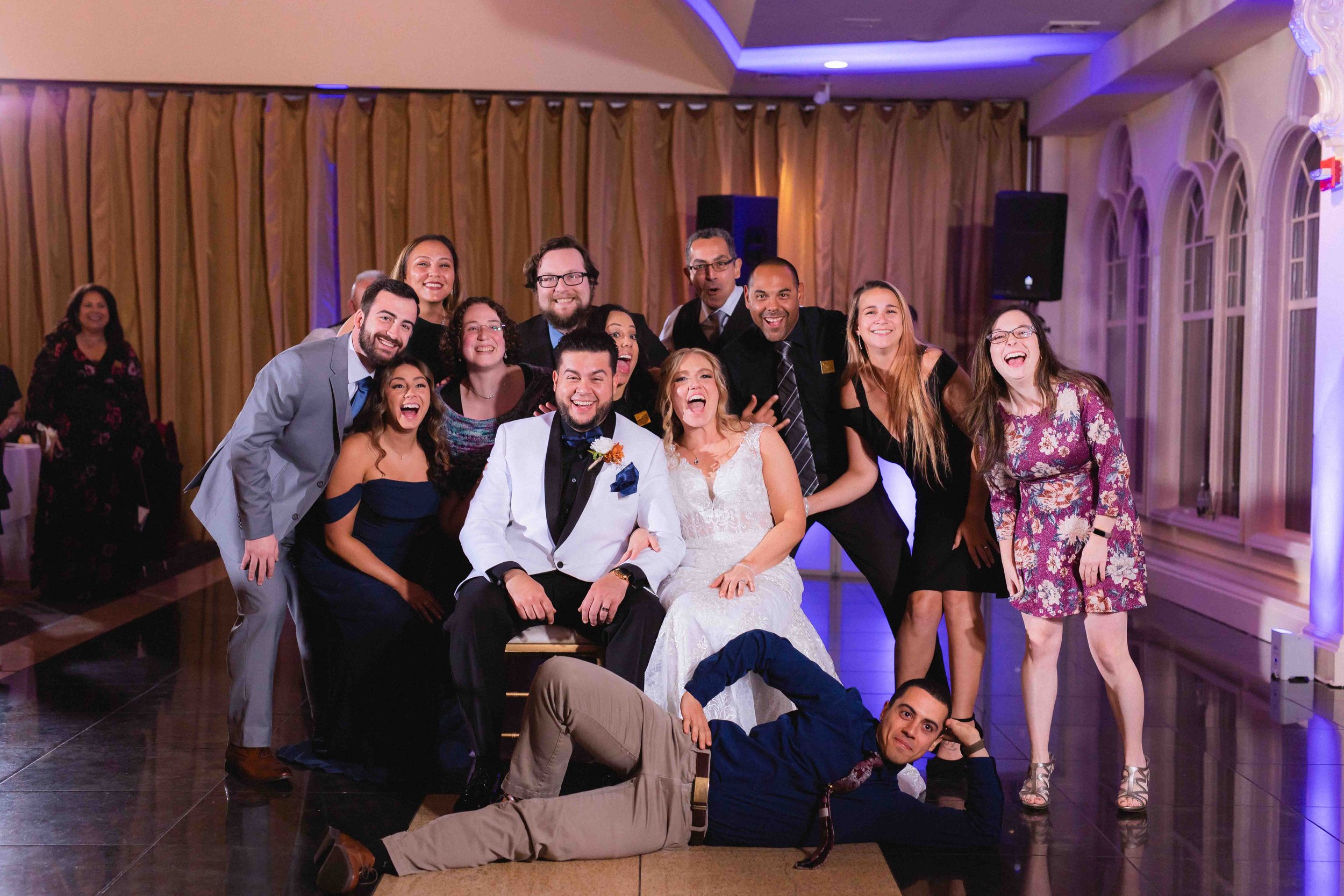 bride and groom smile and laugh with guests during dance floor photo dash during reception in ballroom at the waterview wedding venue in monroe ct