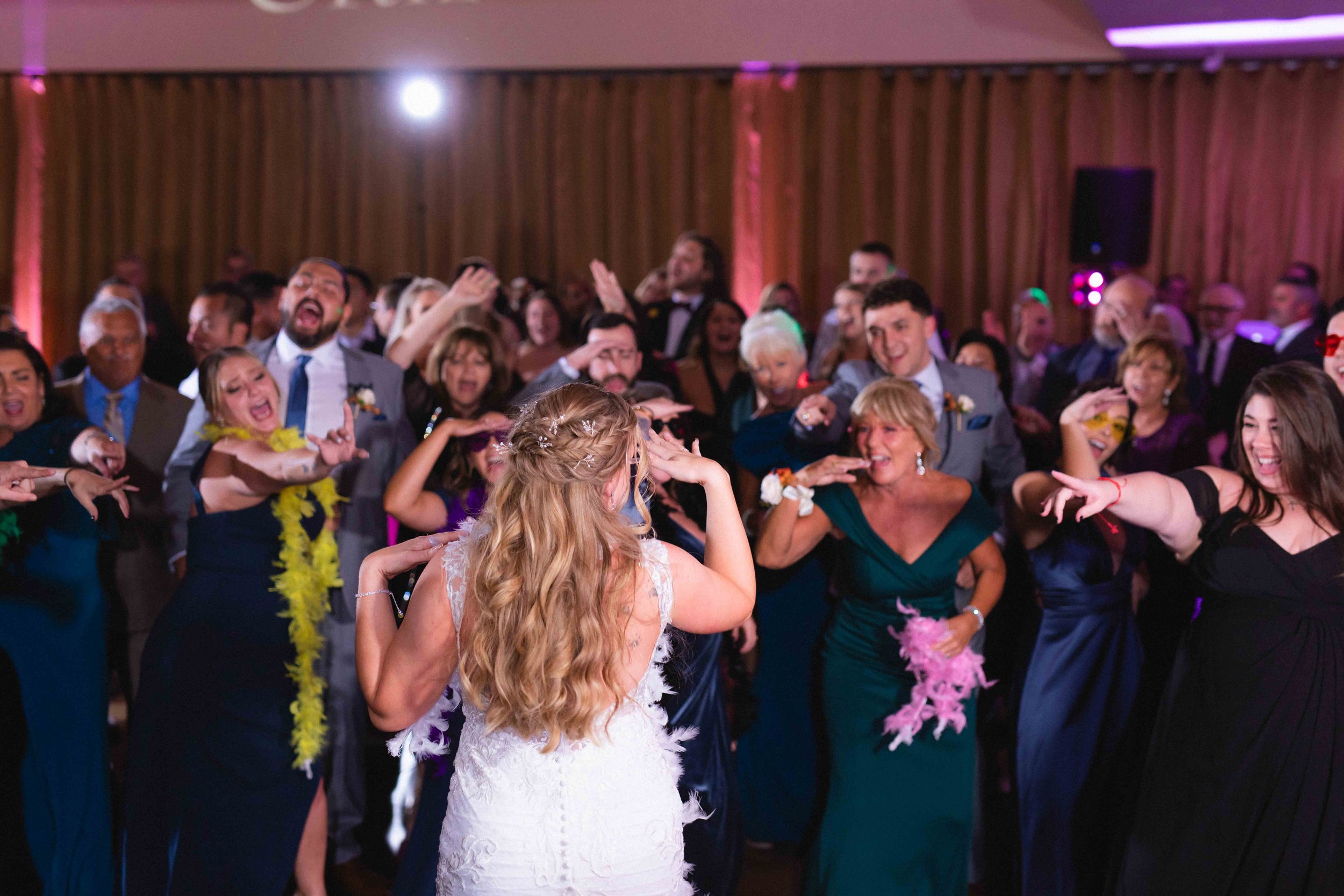 bride shakes hands at wedding guests for choreographed flash mob dance during reception in ballroom at the waterview wedding venue in monroe ct