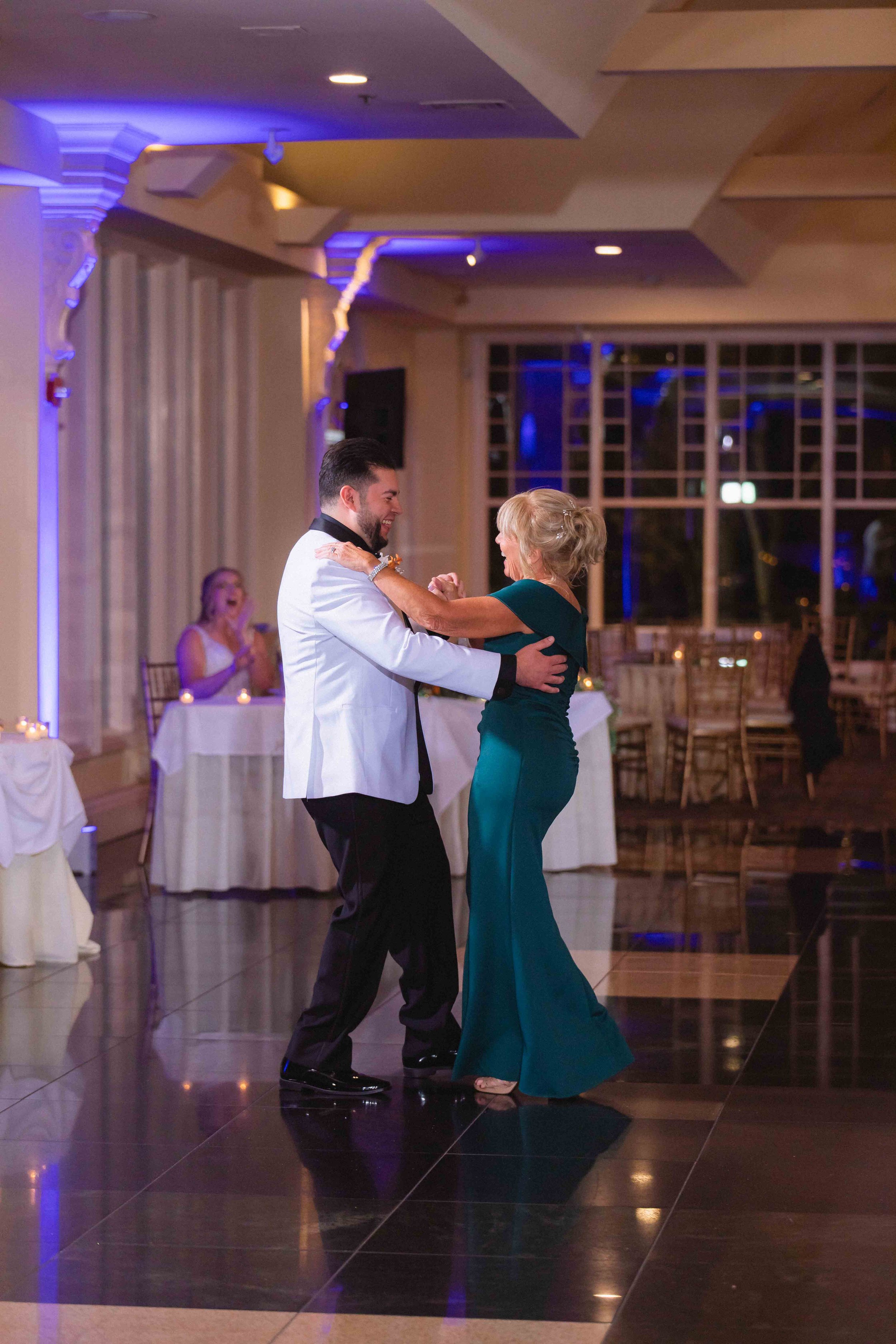 groom dances with bride's mother in ballroom during reception at the waterview wedding venue in monroe ct