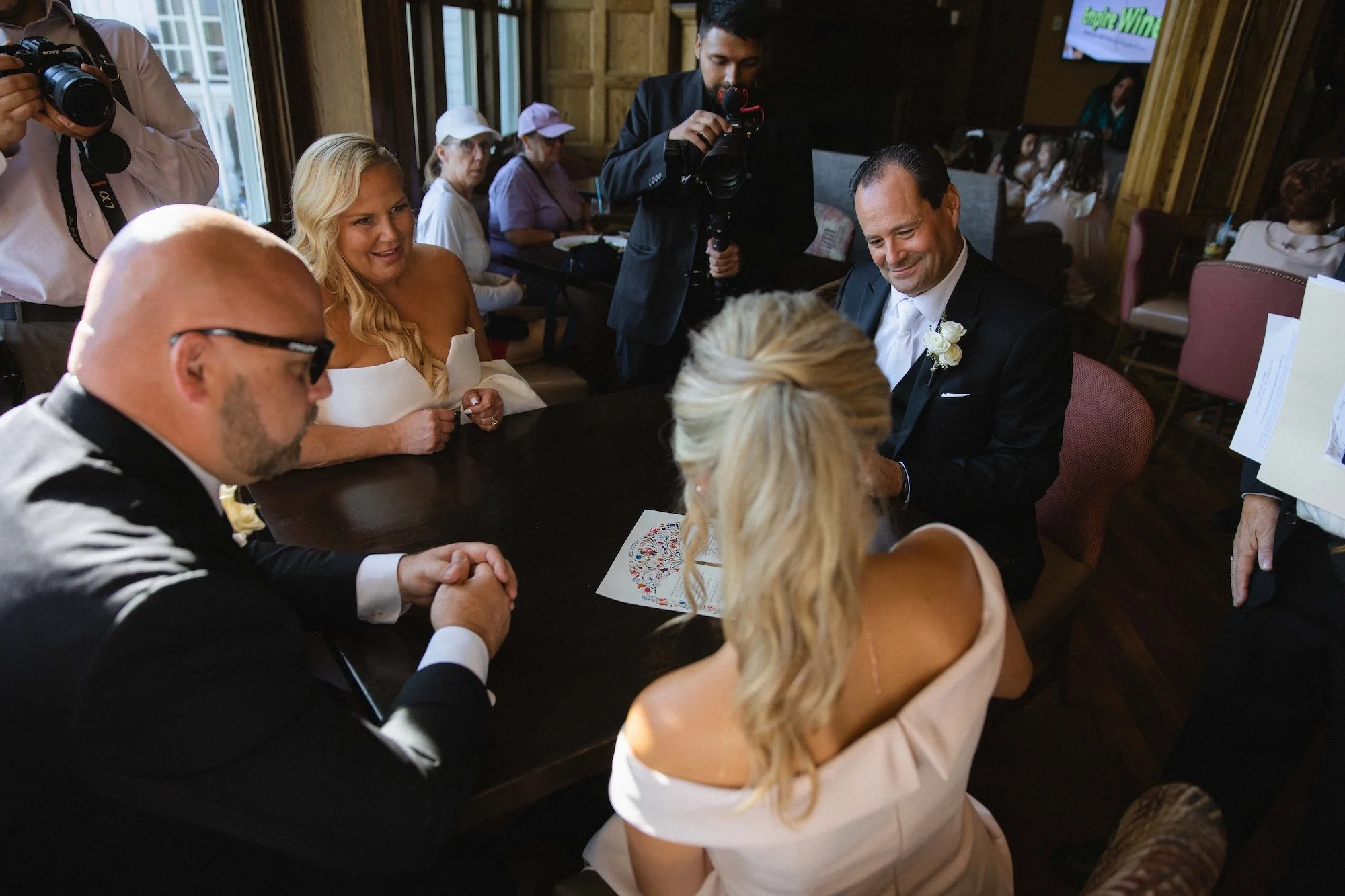 bride's daughter signing ketubah wedding contract in the restaurant before wedding at the sagamore resort in bolton landing on lake george ny