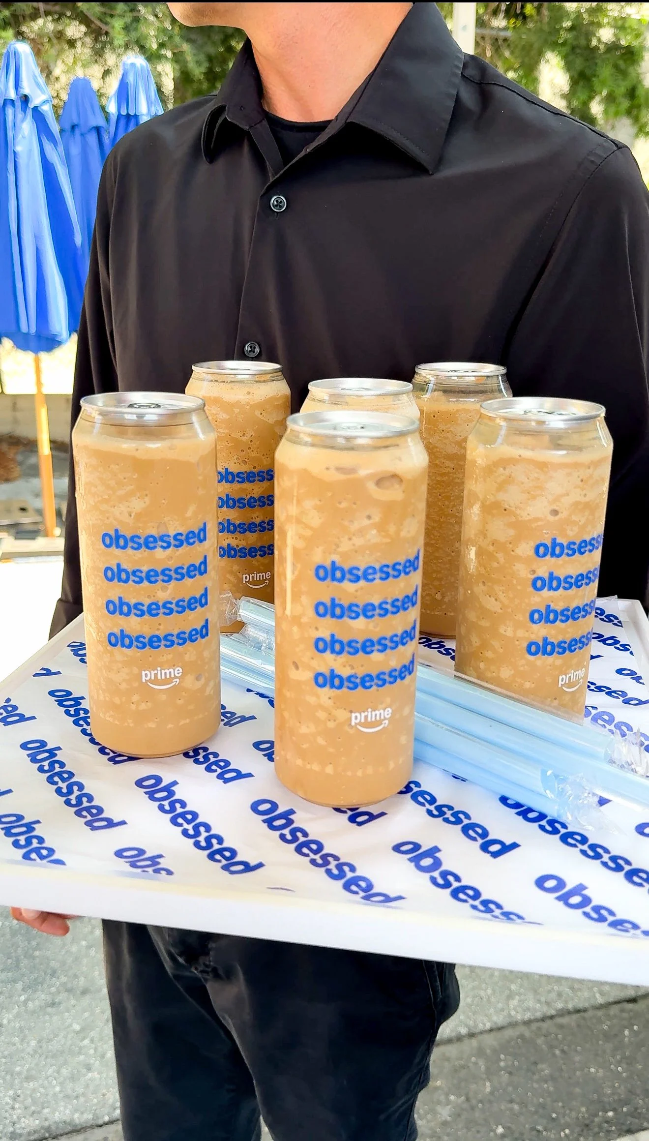 Person holding a tray of Starbucks drinks with the word 'obsessed' printed on the cups and the tray liner.