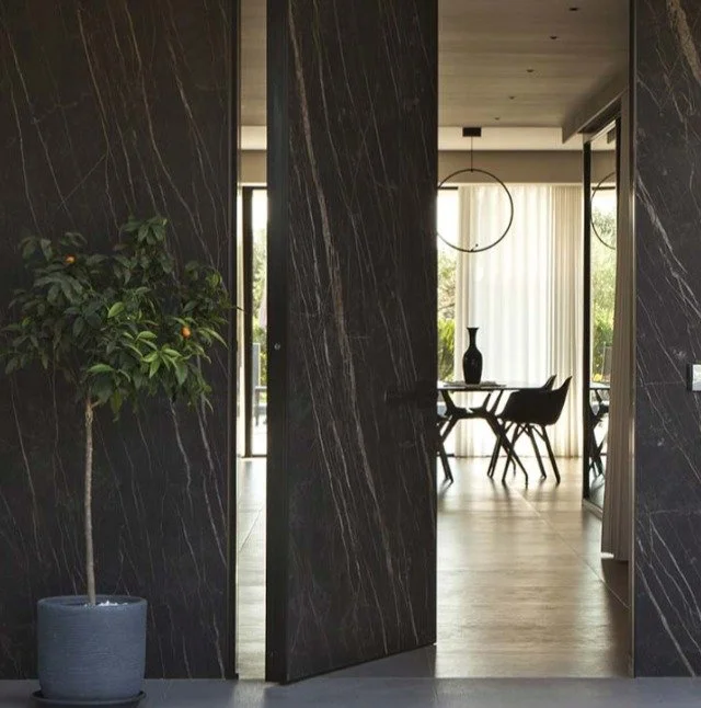 Synua by @oikos represents the evolution of entrance architecture&mdash;a vertical pivot door engineered for grand residential openings that can reach up to 3000mm width and 6200mm height. Installed coplanar with the wall, Synua creates seamless tran