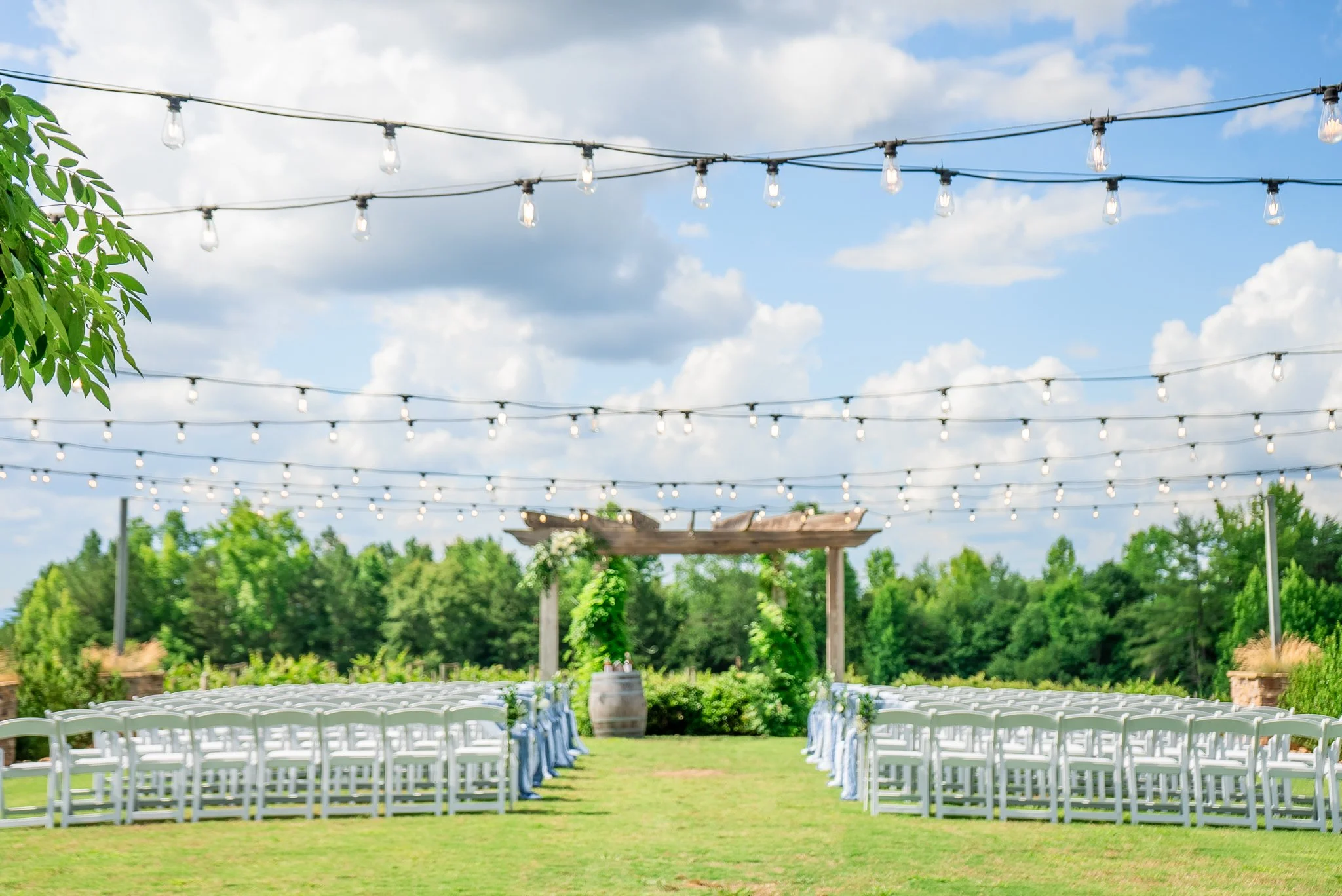 Outdoor wedding ceremony setup at Spinning Leaf at the Vineyard in Shelby, NC with rows of chairs and string lights.