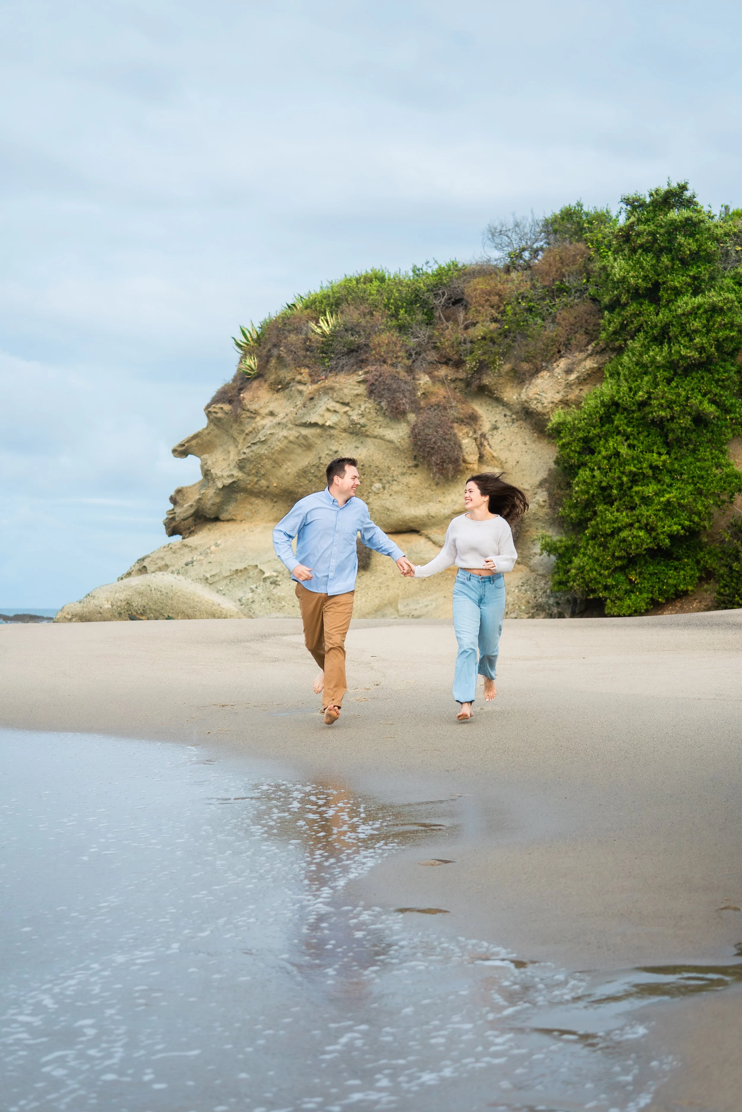 laguna-beach-couples-photographer-running-along-shore.jpg