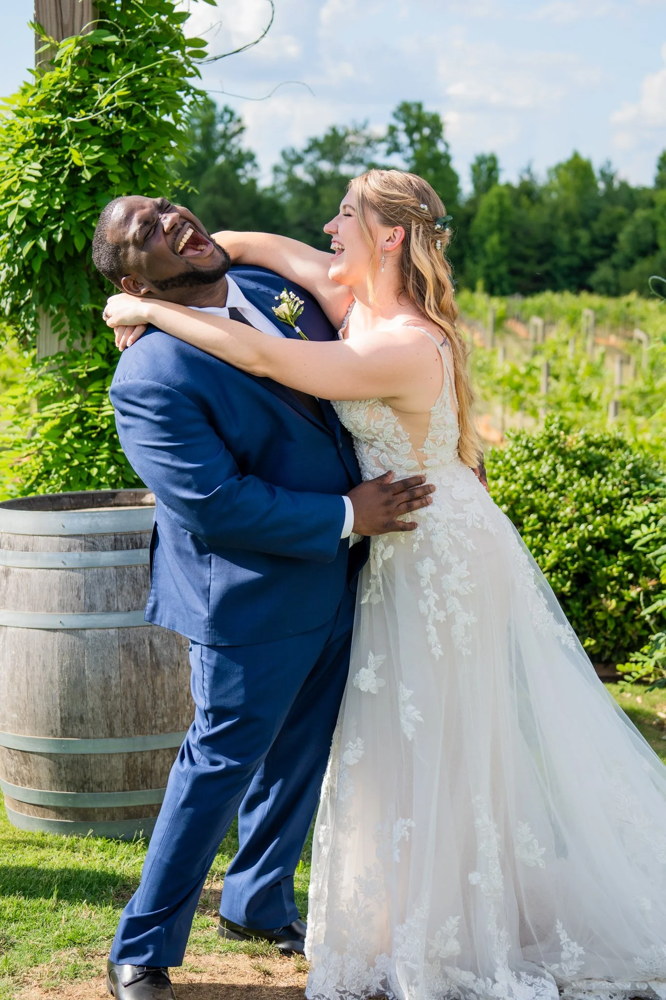 Rebecca and JaNathan laughing together during their vineyard wedding portraits at Spinning Leaf at the Vineyard in NC.