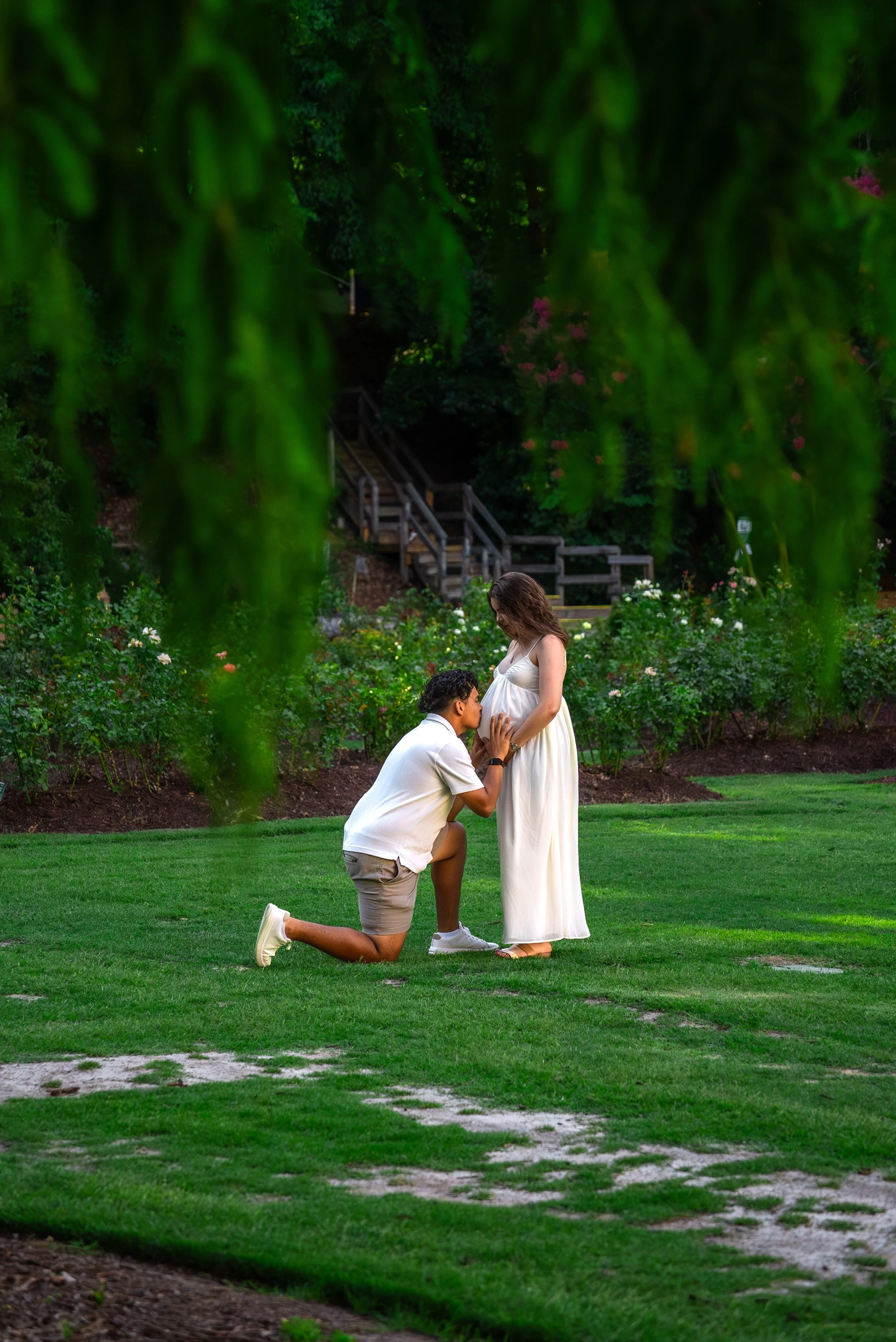 raleigh-rose-garden-raleigh-nc-maternity-session-kneeling-kiss.jpg