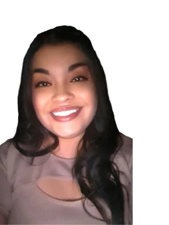 A young woman smiling with dark hair, makeup, and a beige top with a cutout, against a plain background.