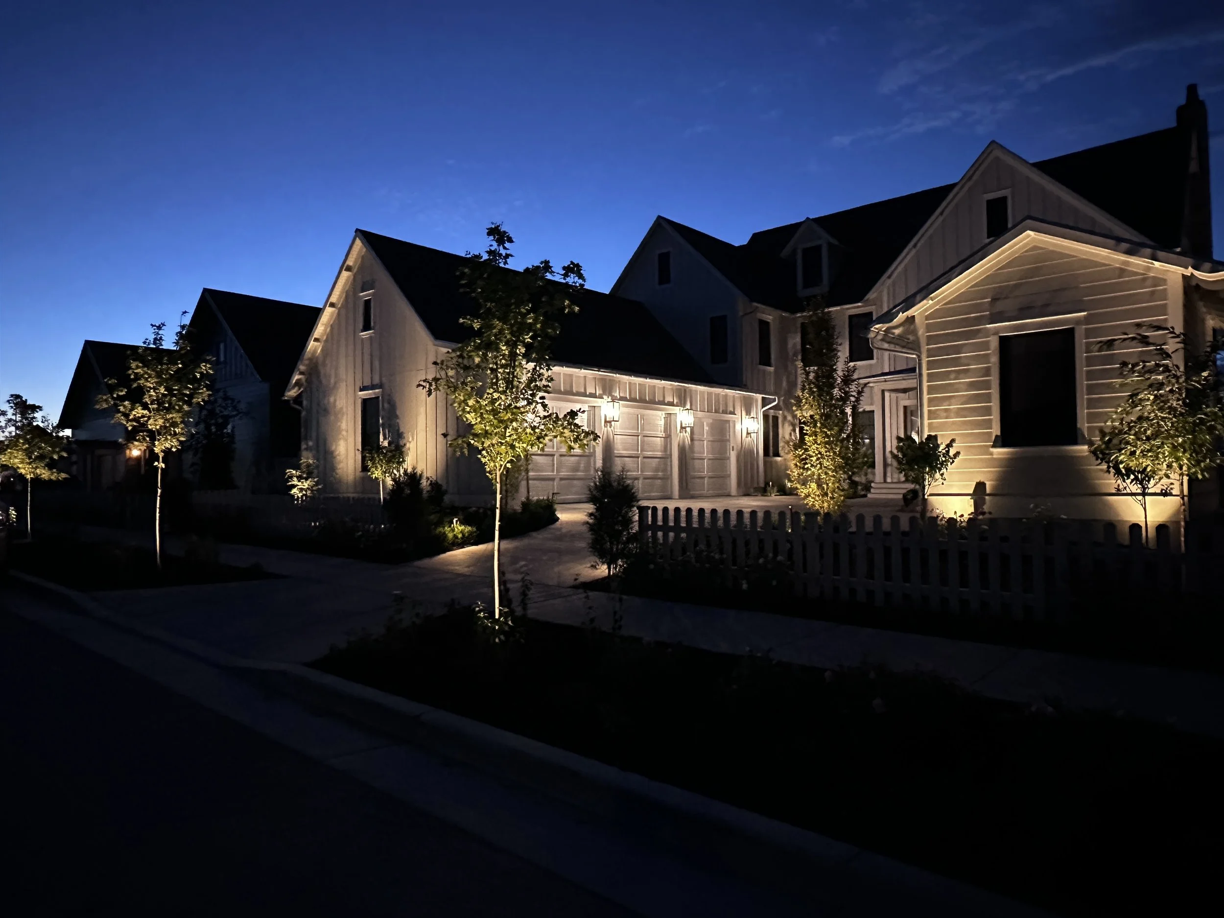 Landscape lighting by Kodiak Landscape® in Cottonwood Heights, UT illuminates a beautiful home and accents pathways and landscaping.
