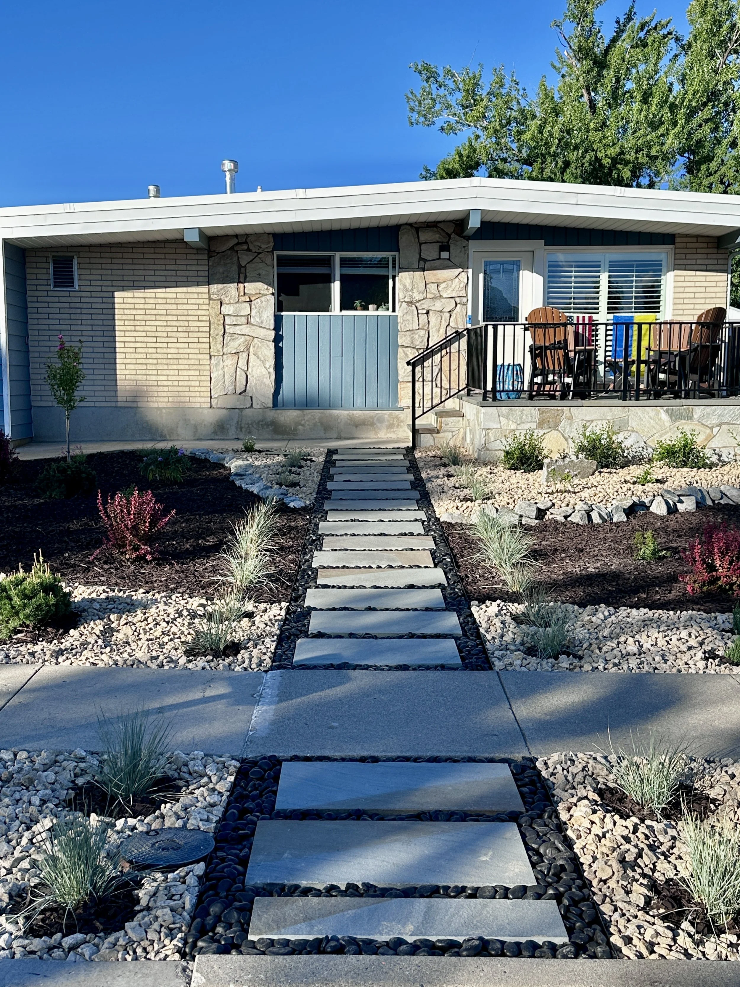 Xeriscaped yard in Cottonwood Heights, UT by Kodiak Landscape® with Pennsylvania bluestone pathway, Mexican beach cobble, decorative rock, perennial flowers, drip irrigation, shade trees and mulch. Super low maintenance!