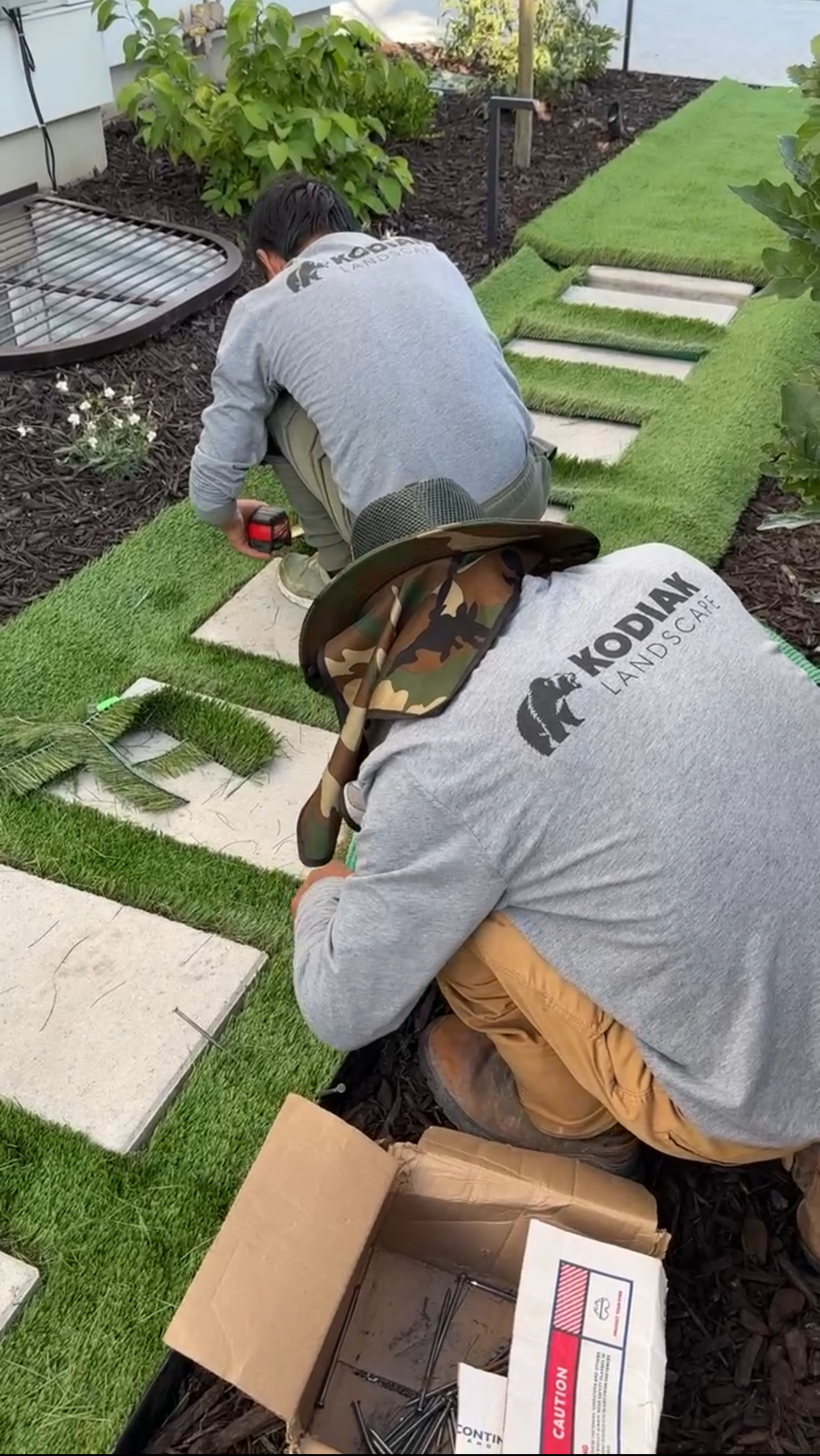 Artificial turf installed around concrete steps by Kodiak Landscape®