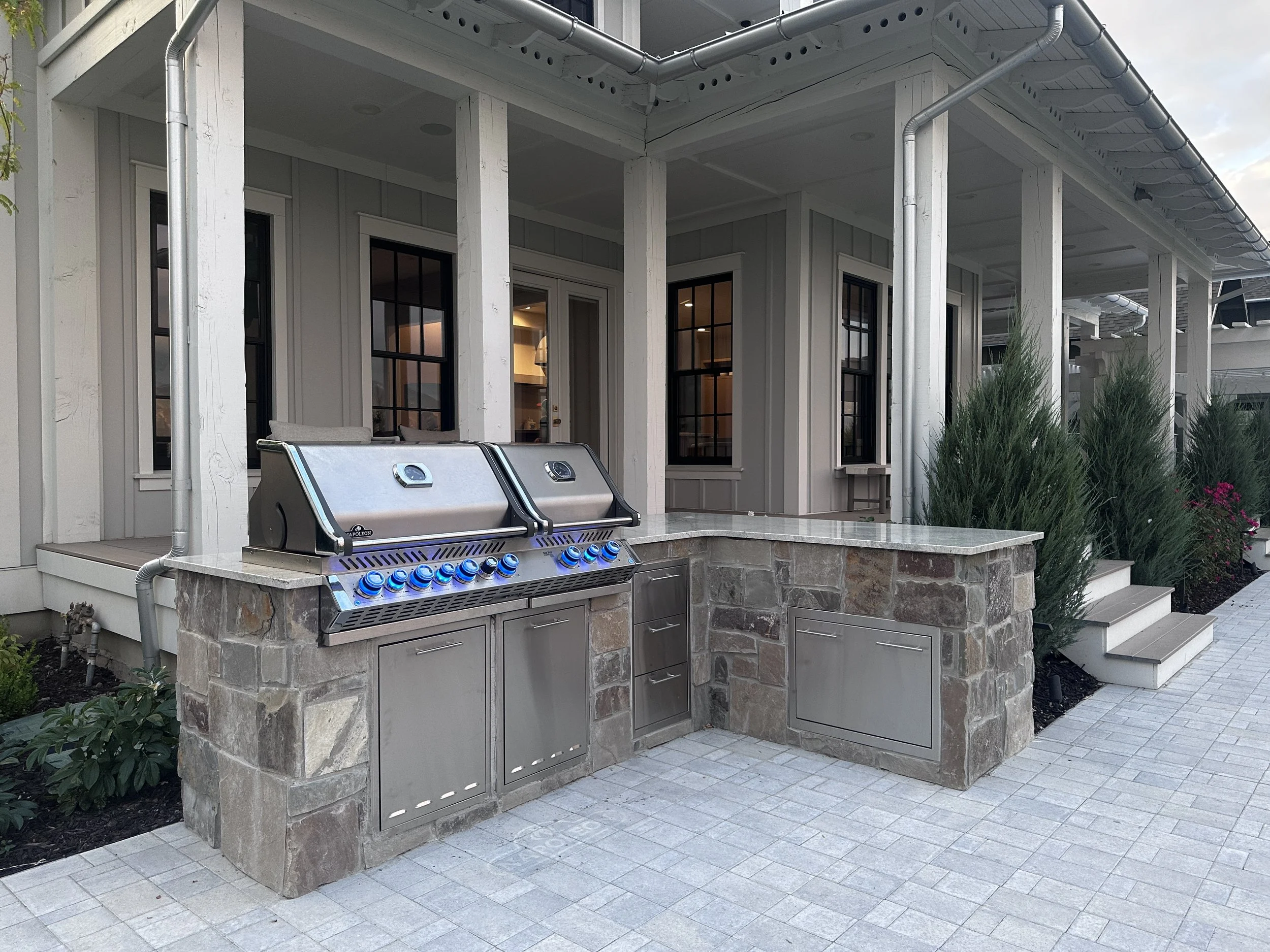 Custom outdoor grill by Kodiak Landscape® in Cottonwood Heights, UT with granite countertop and natural stone veneer.