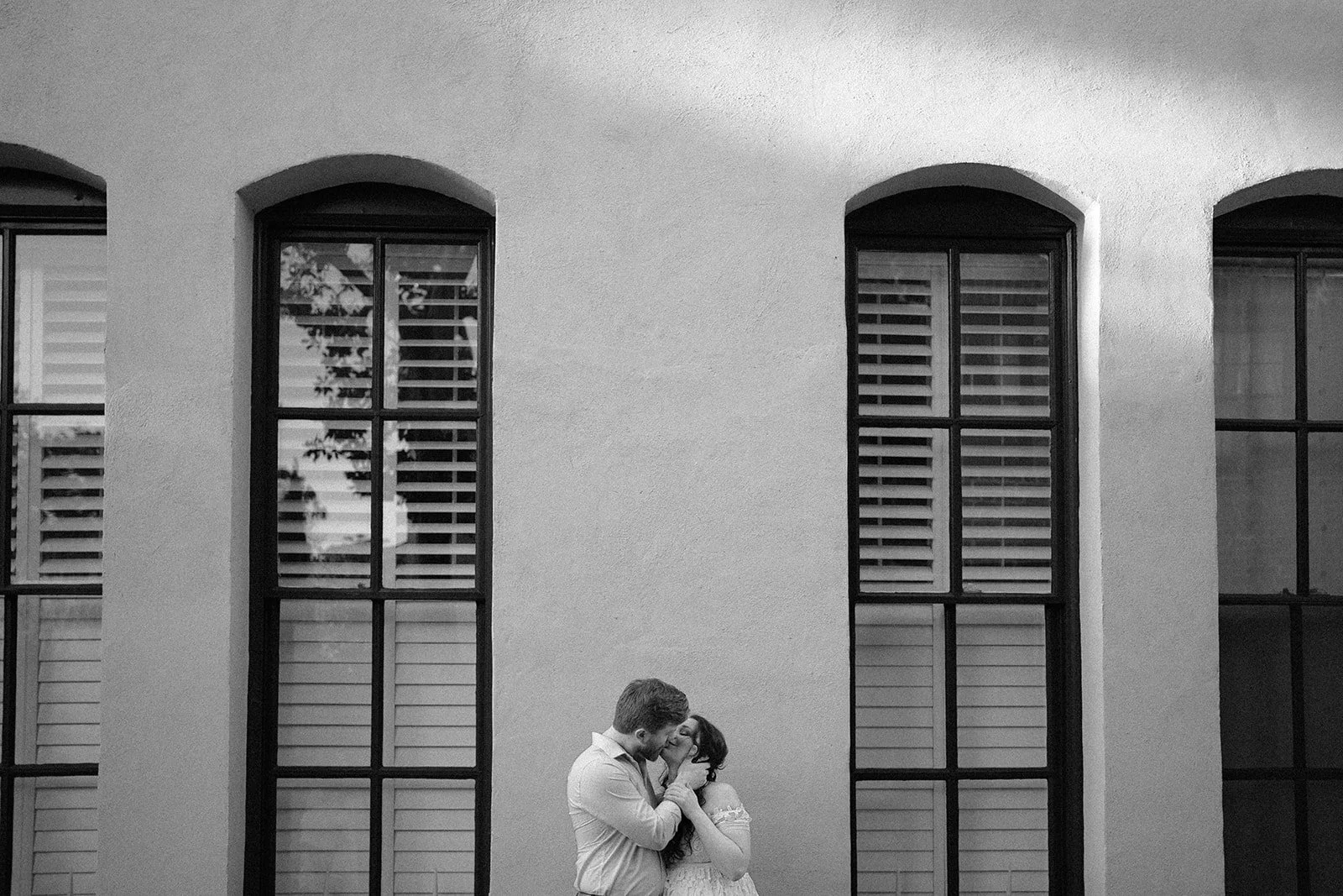 Pregnant couple kissing in front of old building in charleston, south carolina.