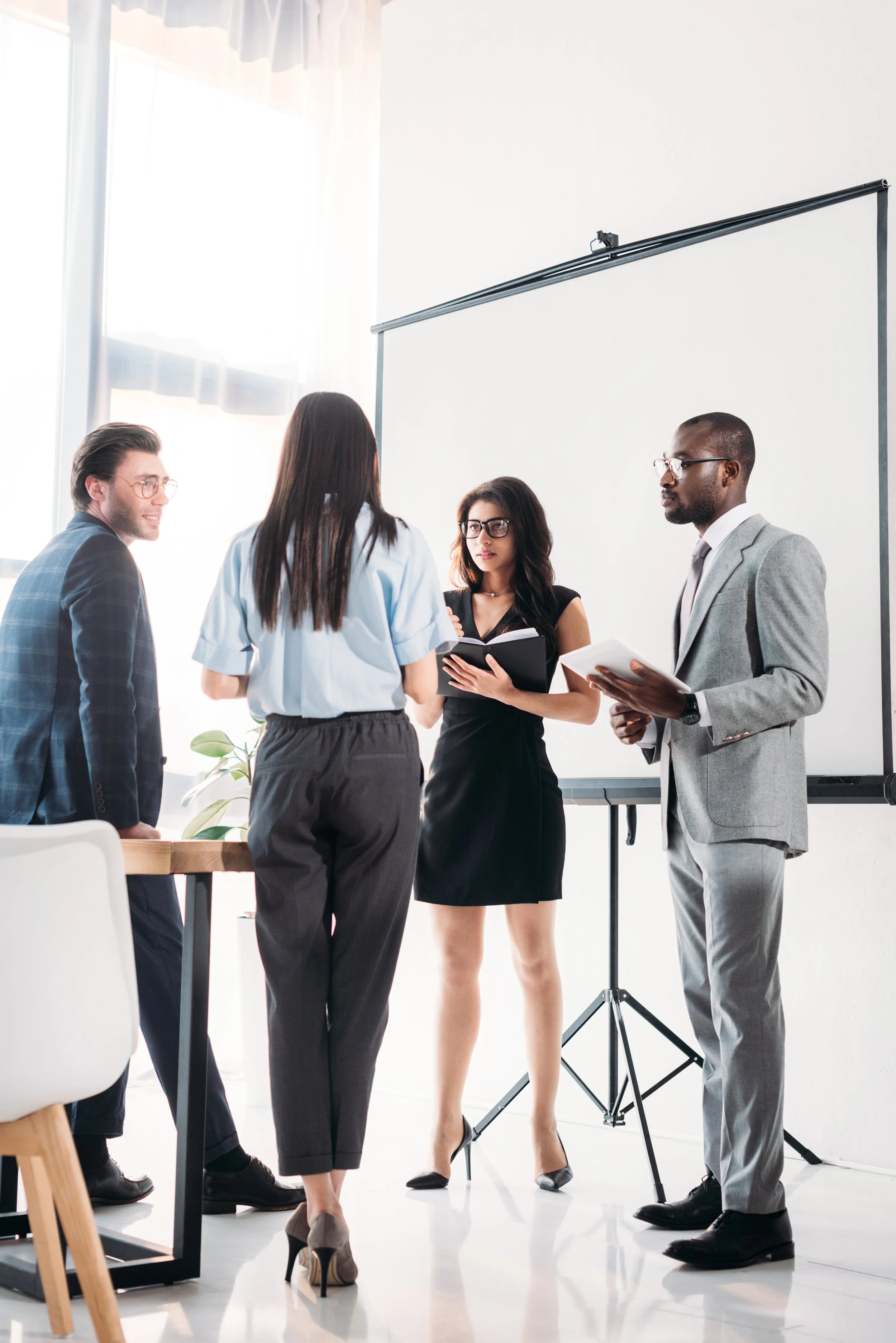 4 coworkers standing and communicating