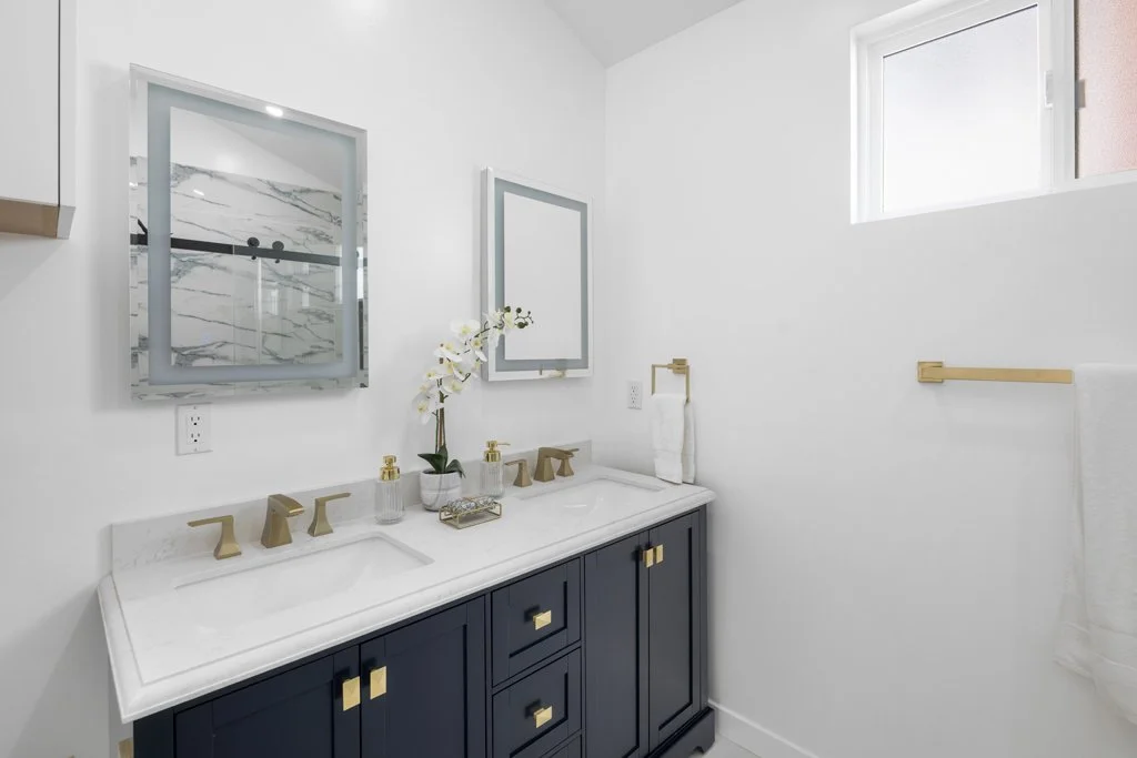 Modern bathroom with dual sinks and gold fixtures – interior real estate photography for luxury homes in Los Angeles by Intuition Real Estate Media.