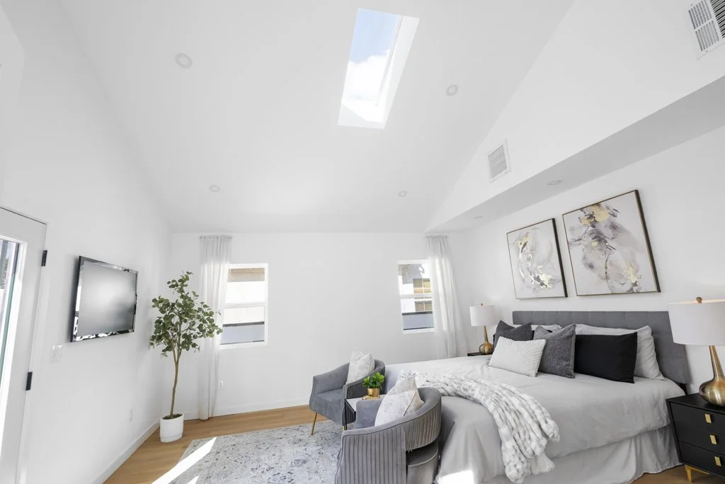 Modern Los Angeles bedroom with skylight and gray bedding – affordable real estate photography by Intuition Real Estate Photography & Imaging with gold-accent side tables and abstract art.