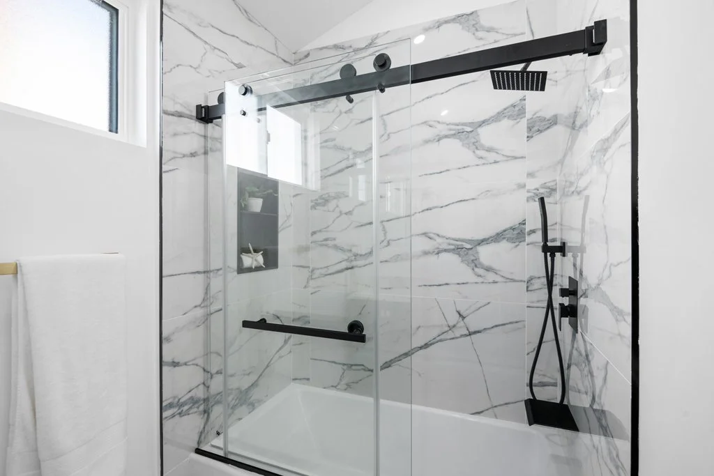 Best luxury bathroom photo for real estate listings – Los Angeles marble shower with black fixtures, shot by Intuition Real Estate Photography & Imaging.