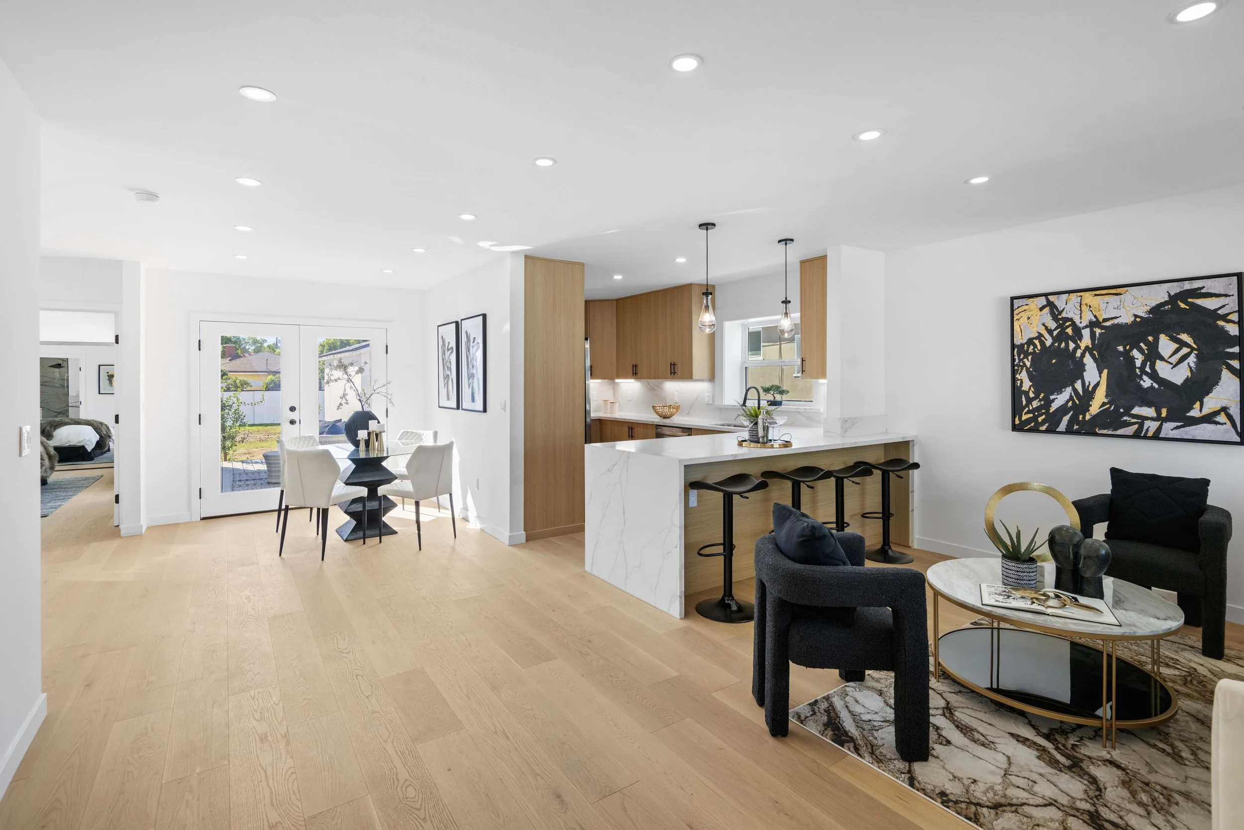 Stylish Los Angeles open-concept layout with hardwood floors, marble kitchen finishes, and designer staging — photographed by Intuition Real Estate Media.