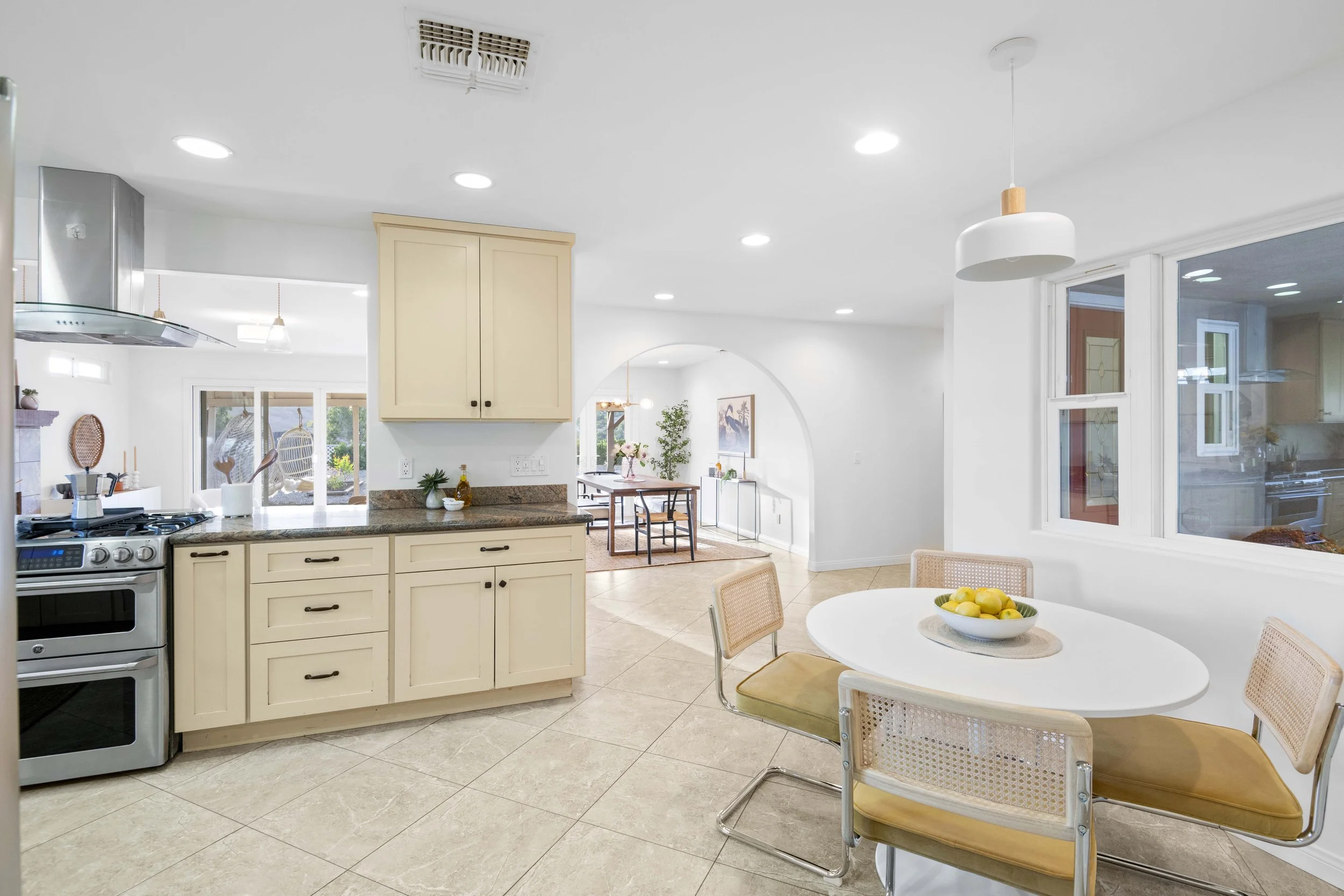 Bright open-concept kitchen and dining area with granite counters and patio access — Los Angeles real estate marketing photo by Intuition Real Estate Media.