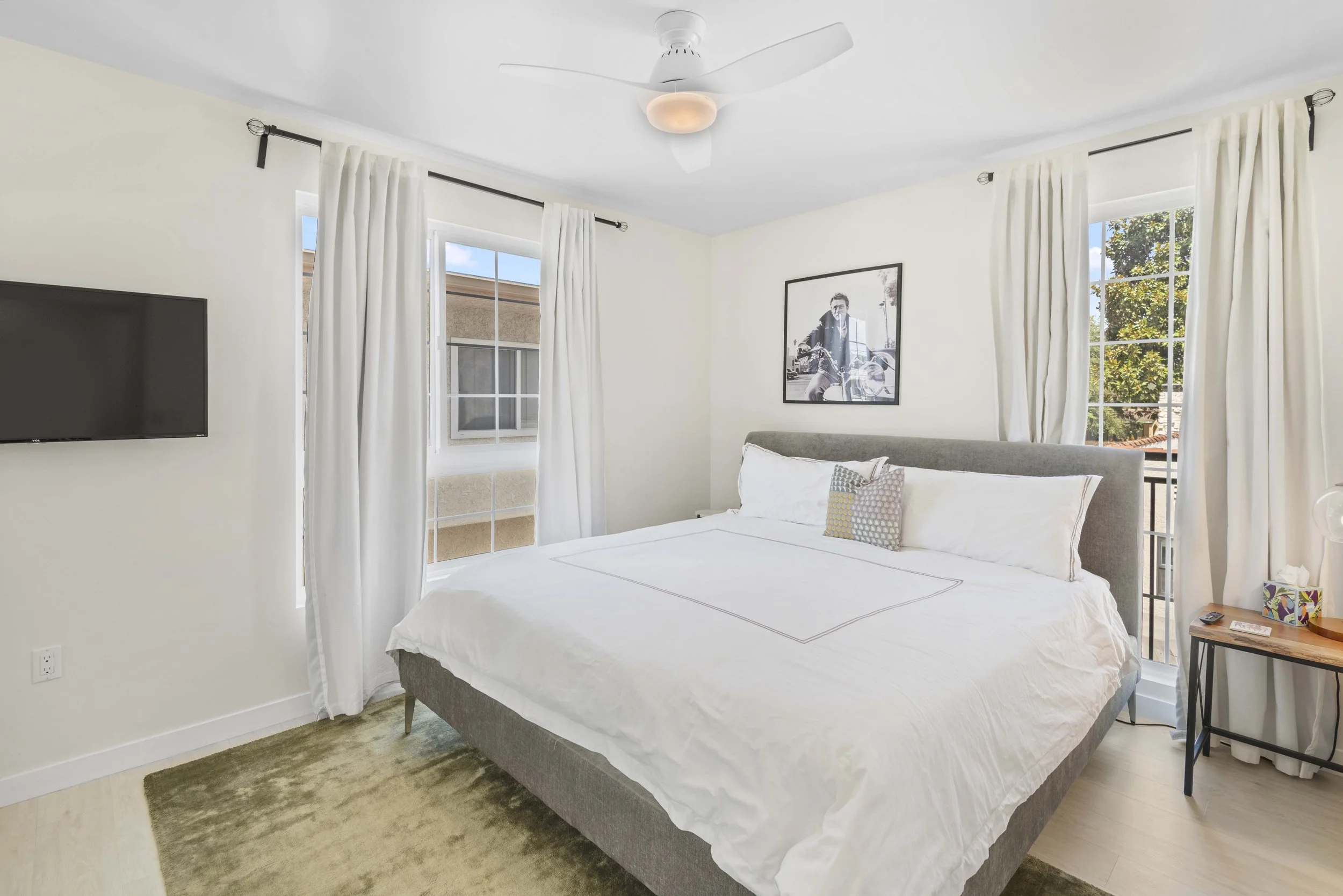 Bright Los Angeles bedroom with white linens and wall-mounted TV – photographed by Intuition Real Estate Photography & Imaging for MLS listings and interior styling promotion.