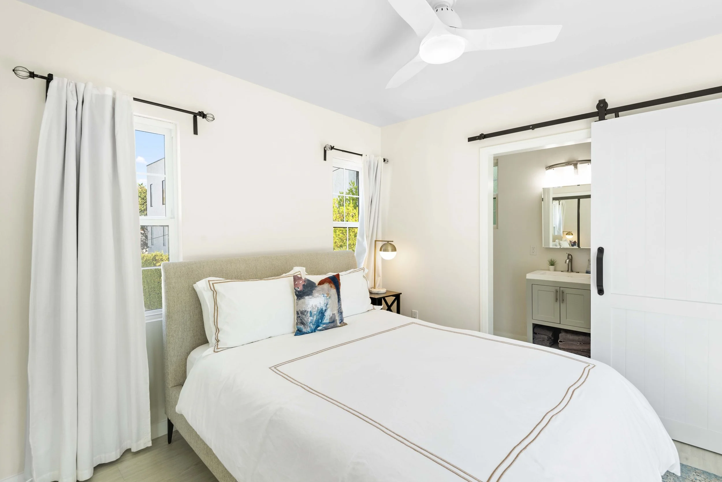 Bedroom with en-suite bath and garden view – real estate interior photo by Intuition Real Estate Media, serving Los Angeles with bright and detailed MLS visuals.