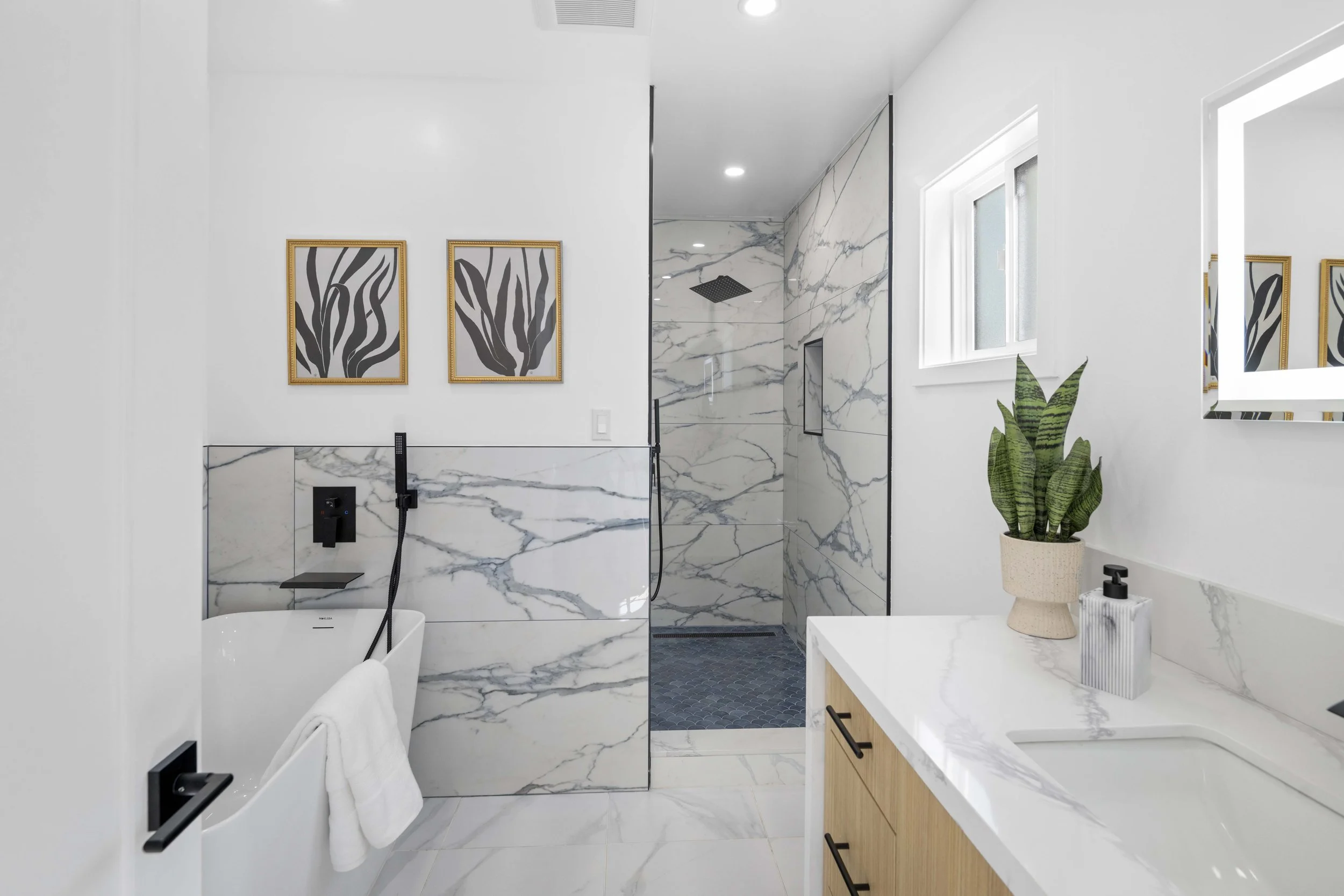 Elegant LA bathroom with marble finishes, rain shower, soaking tub, and botanical accents — luxury listing photo by Intuition Real Estate Media.
