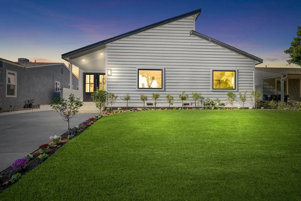 Twilight exterior photo of modern white LA home with flower beds and lawn – captured by Intuition Real Estate Media for luxury real estate listings and twilight sessions.