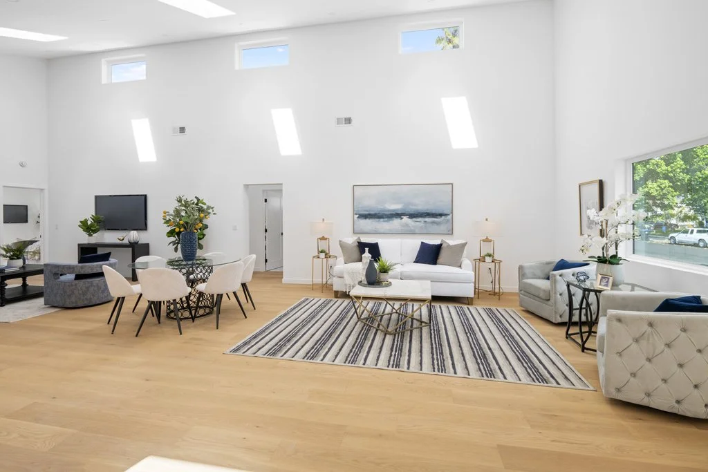 Bright, modern LA living room with natural light, navy decor, and dining table – best interior real estate photography by Intuition Real Estate Media.