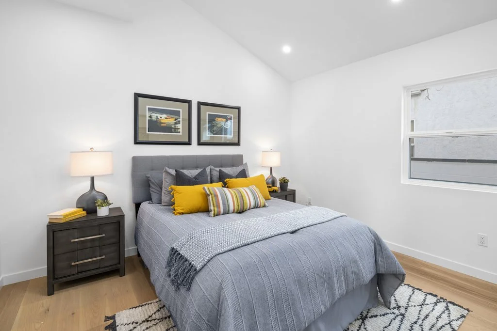 Affordable interior real estate photography – stylish LA bedroom with patterned bedding, race car wall art, and modern staging by Intuition Real Estate Media.