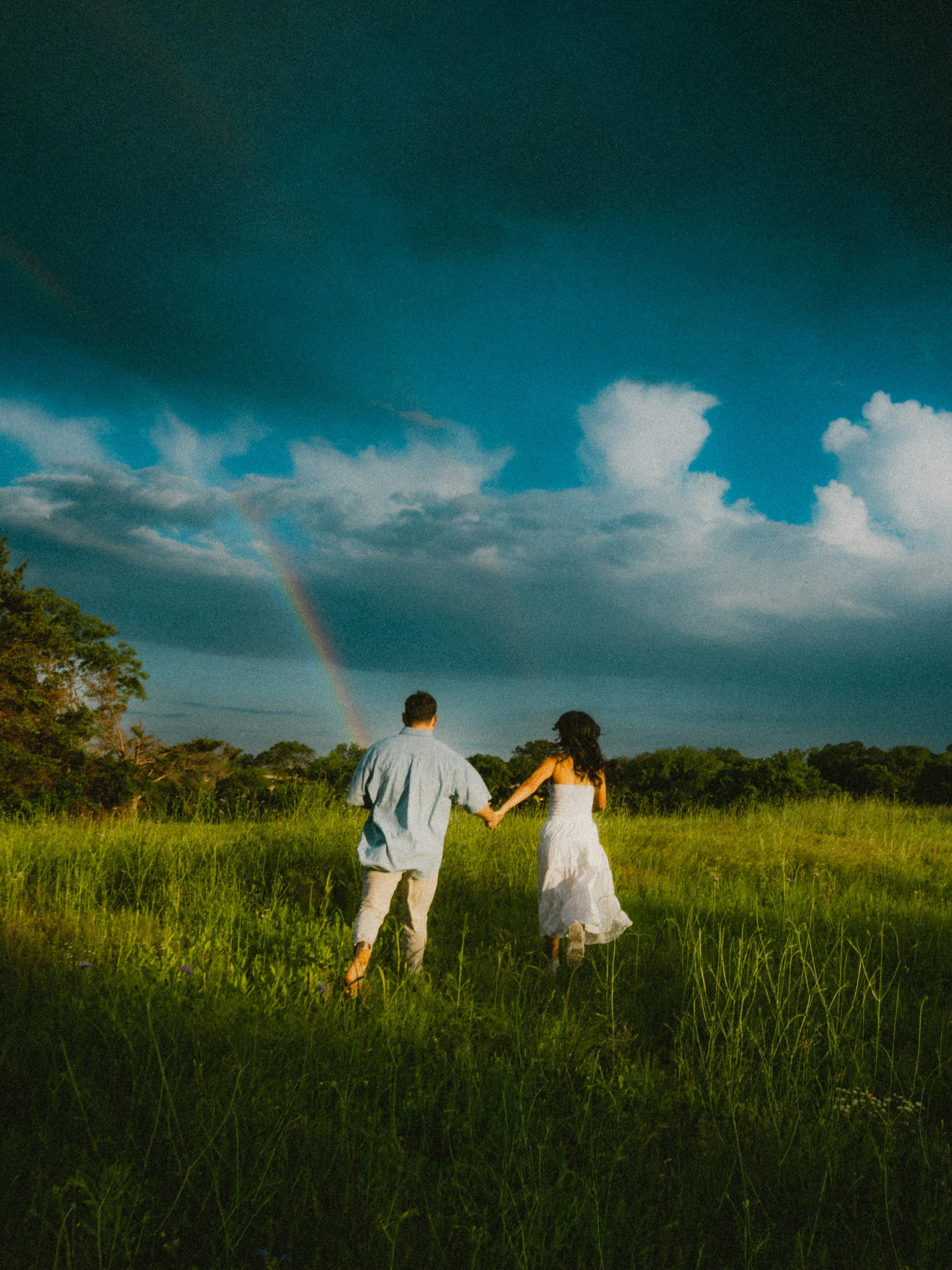  Documentary-style photo of a couple walking toward a rainbow at  Erwin Park in McKinney  after a summer storm. 
