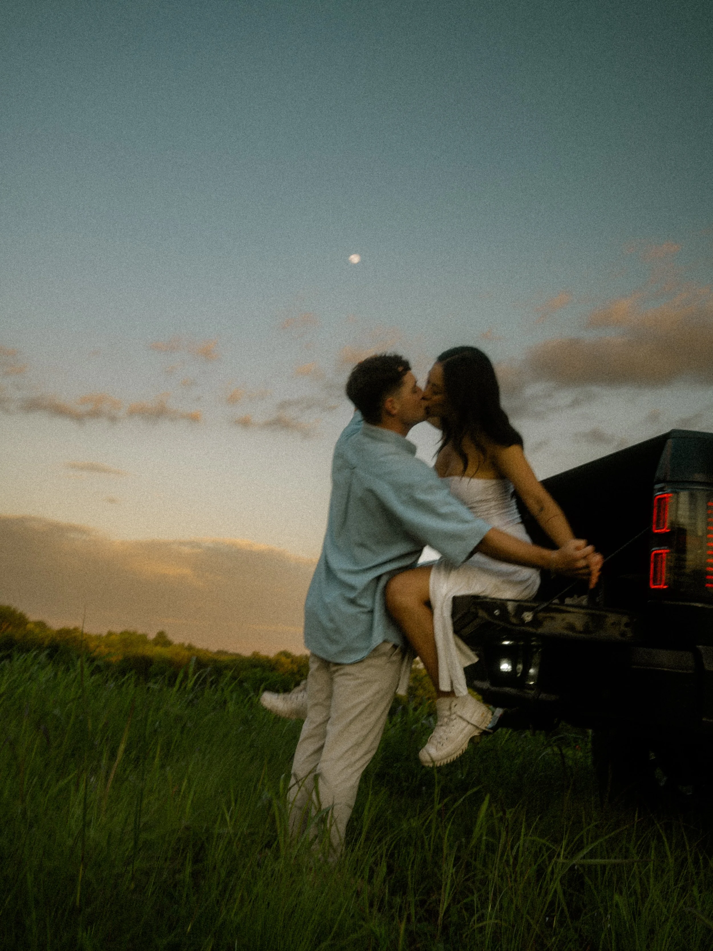  Romantic golden hour session featuring a couple kissing on a truck tailgate at  Erwin Park in McKinney . 