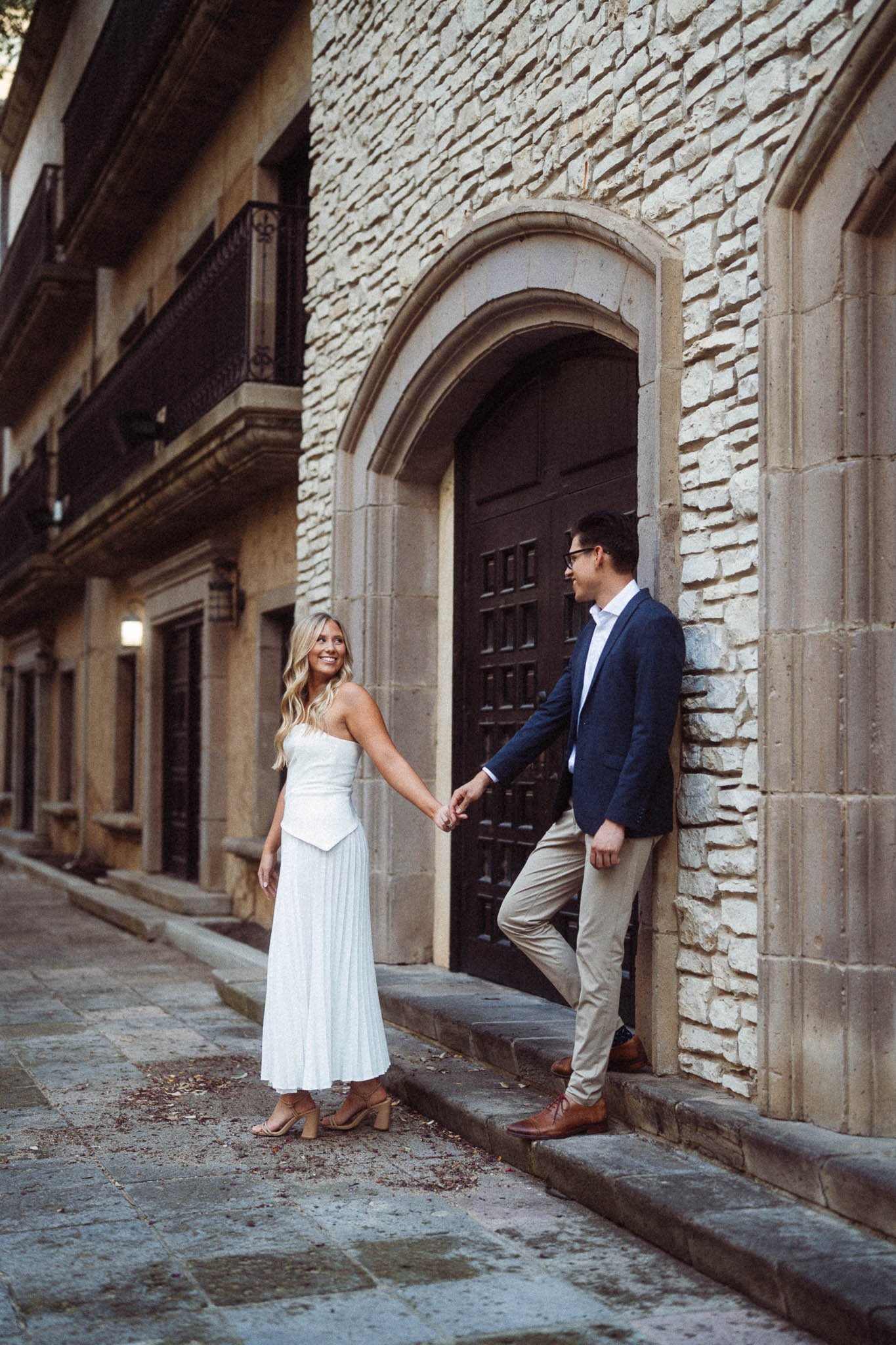 Dallas, Texas engagement session featuring a close-up of a diamond engagement ring with a large oval-cut diamond in a gold setting, surrounded by pink and white carnations.