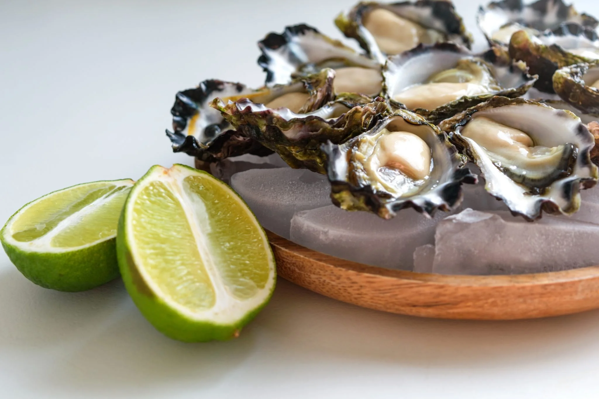 Freshly shucked Bel's Sydney Rock oysters served on ice with lime wedges