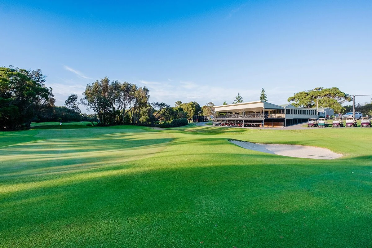 18th hole fairway and bunker with Shoalhaven Heads Golf Club clubhouse in the background