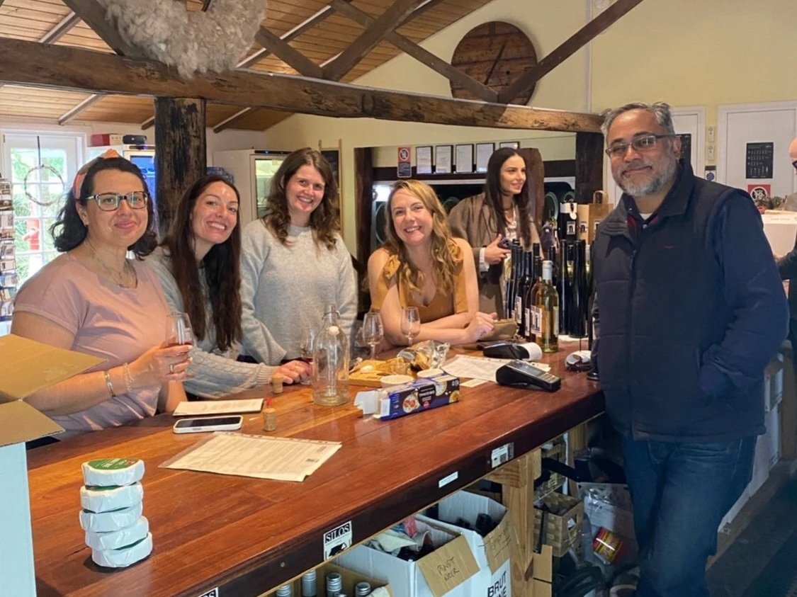 A group of friends enjoying a wine tasting around the timber cellar door bar inside Silos Estate winery near Berry in the Shoalhaven region.