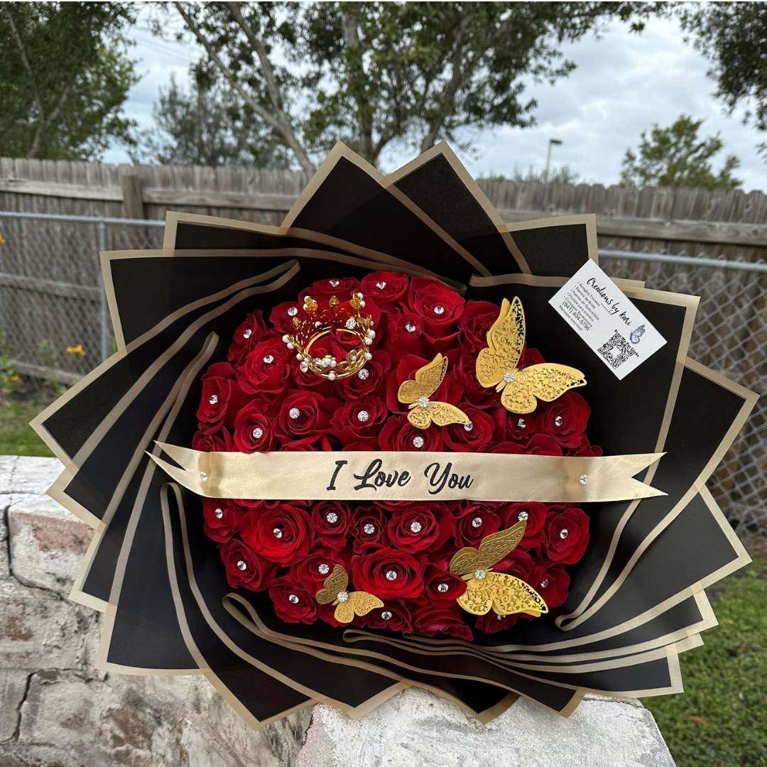 Red rose bouquet with gold butterfly and crown accents and “I Love You” banner