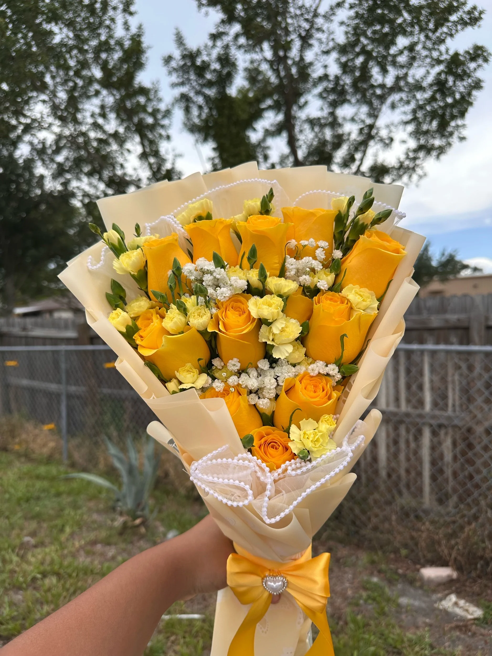 Yellow rose bouquet with yellow mini carnations, baby’s breath, white pearl mesh, and yellow butterfly-patterned floral wrapping.